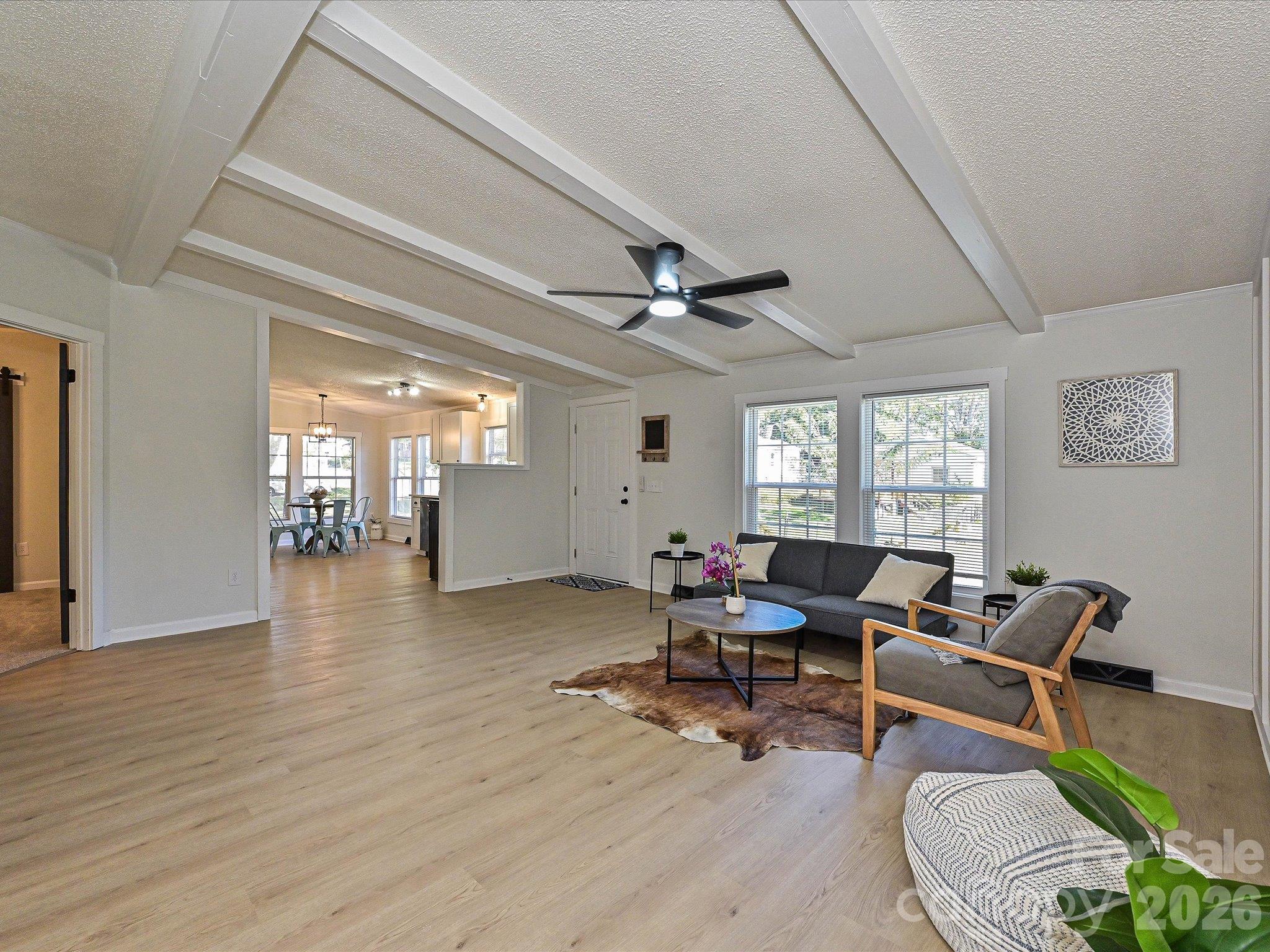 View of living room from hallway entrance. Open floor plan to kitchen. Primary suite entrance shown on left hand side. - 1711 Trexlar Avenue, Gastonia