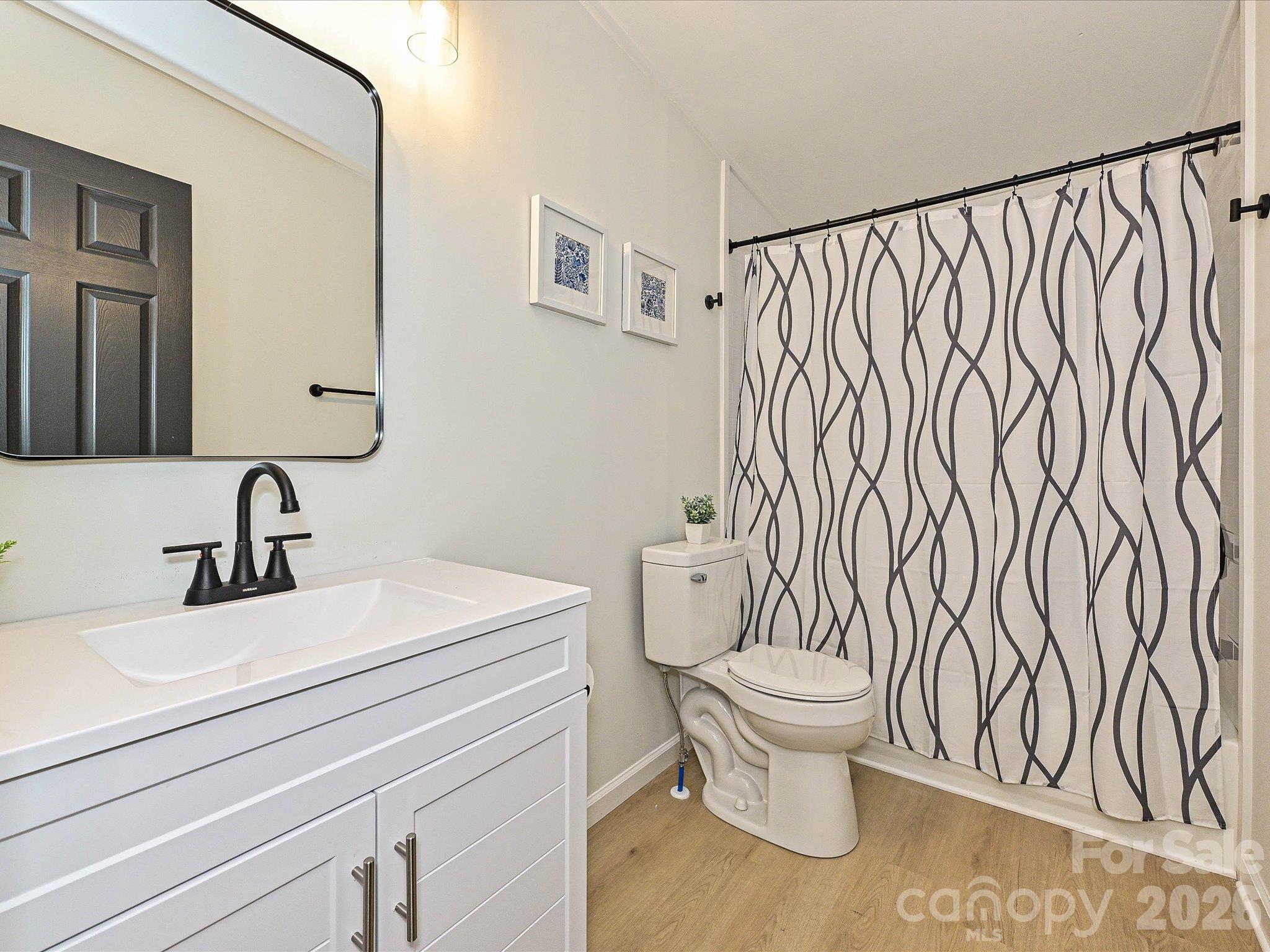 View of hall bathroom with new vanity, faucet, farmhouse mirror, lights, etc. - 1711 Trexlar Avenue, Gastonia