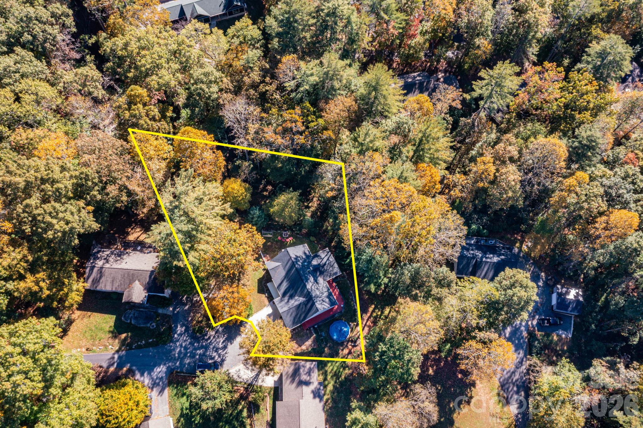 Overhead aerial showing the home, driveway, and wooded setting, with approximate property boundaries outlined for reference. - 139 Lone Eagle Lane, Hendersonville