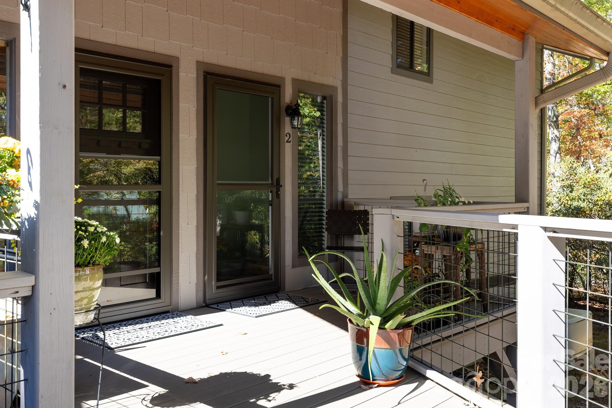 Close-up of the private covered entrance, featuring attractive wood railings and easy access from the parking area. - 524 Three Mile Knob Road, Pisgah Forest