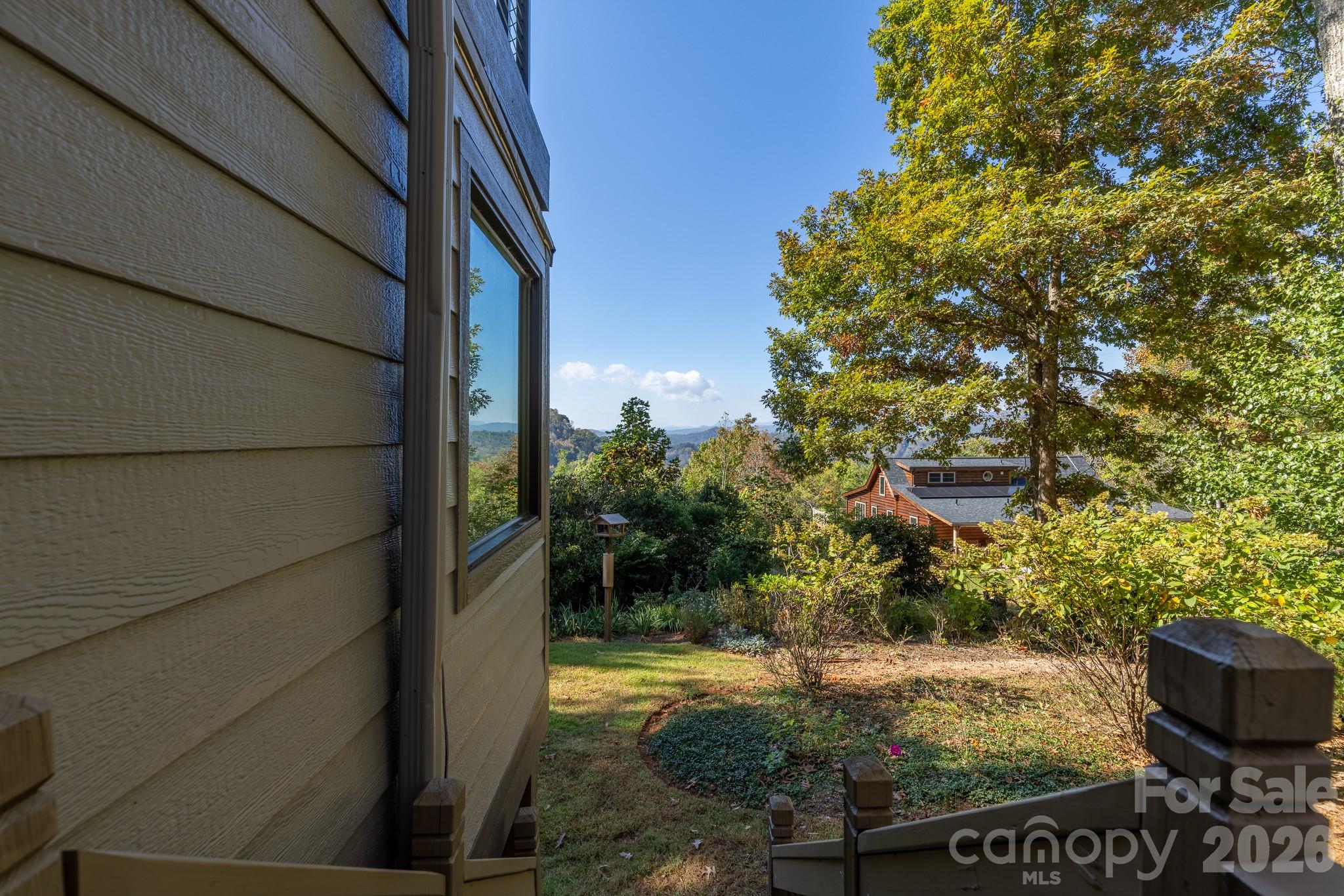 Beautifully landscaped grounds with a glimpse of the distant Blue Ridge Mountains. Storage shed is to the left for easy access. - 524 Three Mile Knob Road, Pisgah Forest