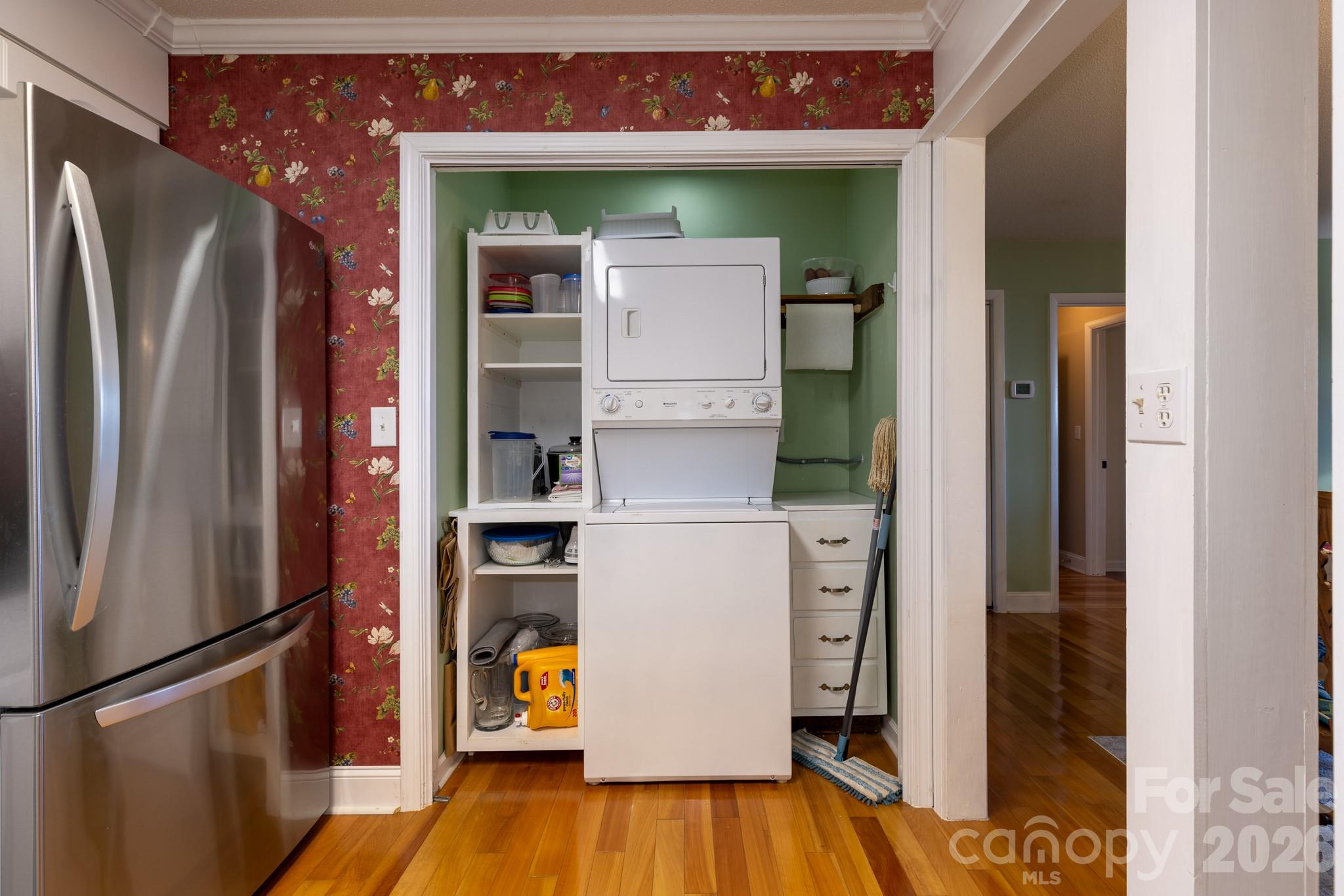 Additional kitchen view showing convenient access to the laundry area, ample cabinetry, and attractive hardwood flooring. - 524 Three Mile Knob Road, Pisgah Forest