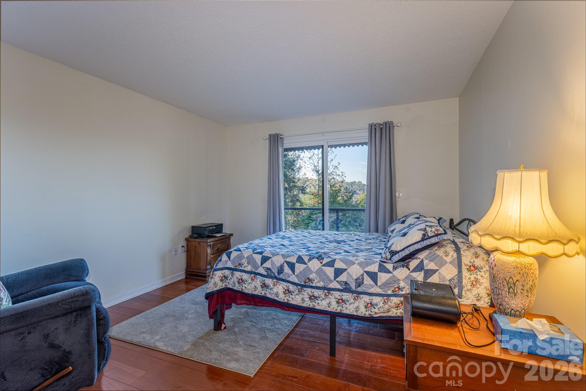 Another view of the bedroom showing direct deck access and beautiful mountain scenery beyond the sliding glass doors. - 524 Three Mile Knob Road, Pisgah Forest