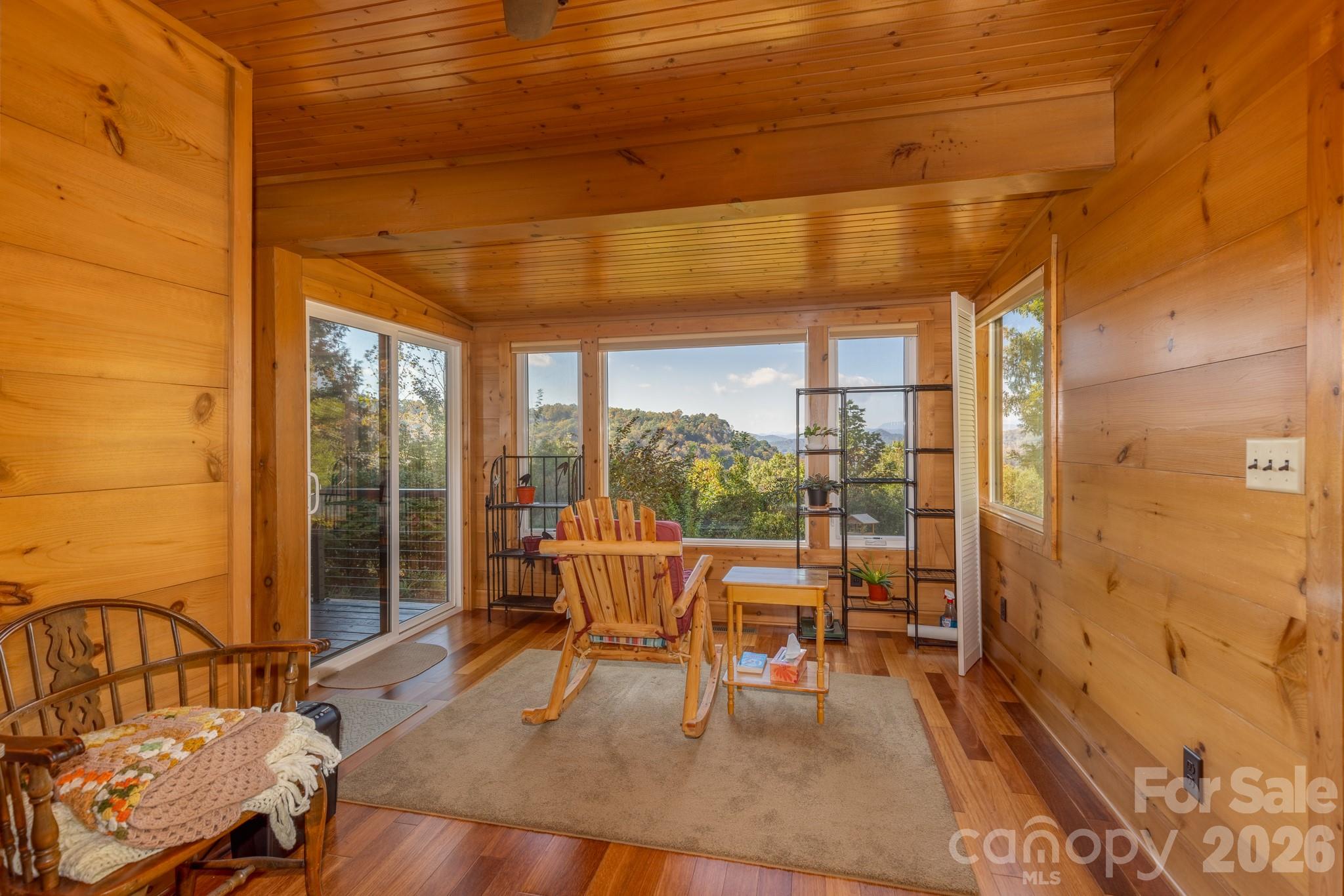 Exceptional sunroom surrounded by windows showcasing gorgeous long-range mountain views. An ideal setting for morning coffee, reading, or simply enjoying the scenery. - 524 Three Mile Knob Road, Pisgah Forest
