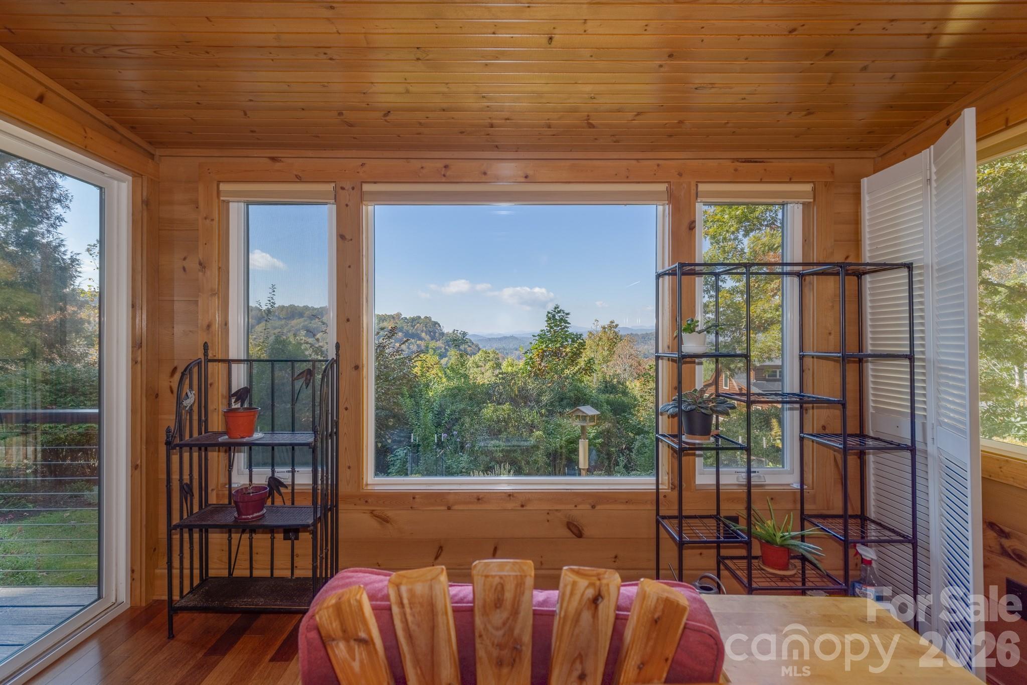 Spectacular mountain views framed by the sunroom expansive windows, bringing the natural beauty of Western North Carolina indoors. - 524 Three Mile Knob Road, Pisgah Forest