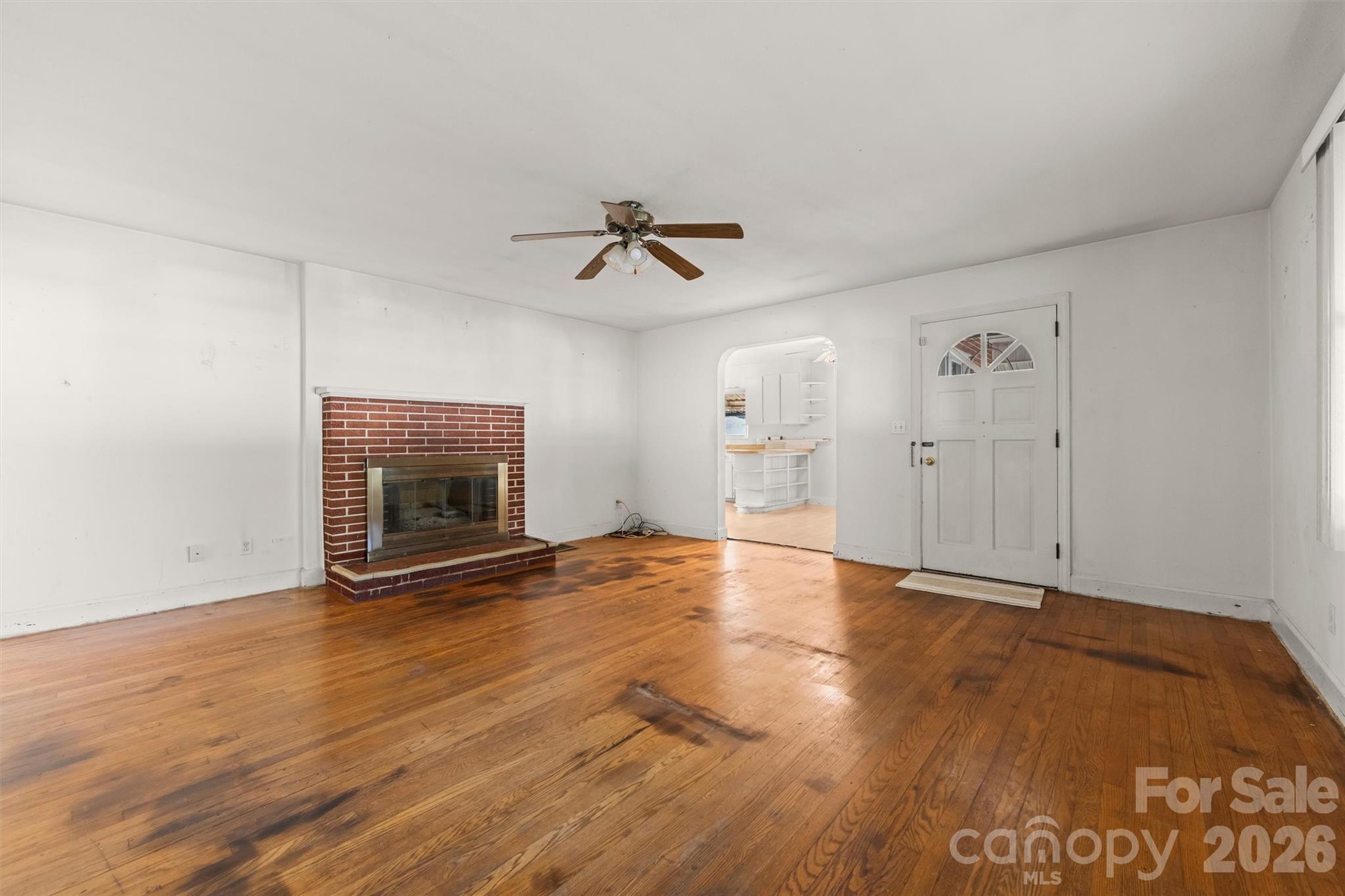Front door onto the covered front porch - living room with original wood floors and brick fireplace - 108 Morgan Street, Canton
