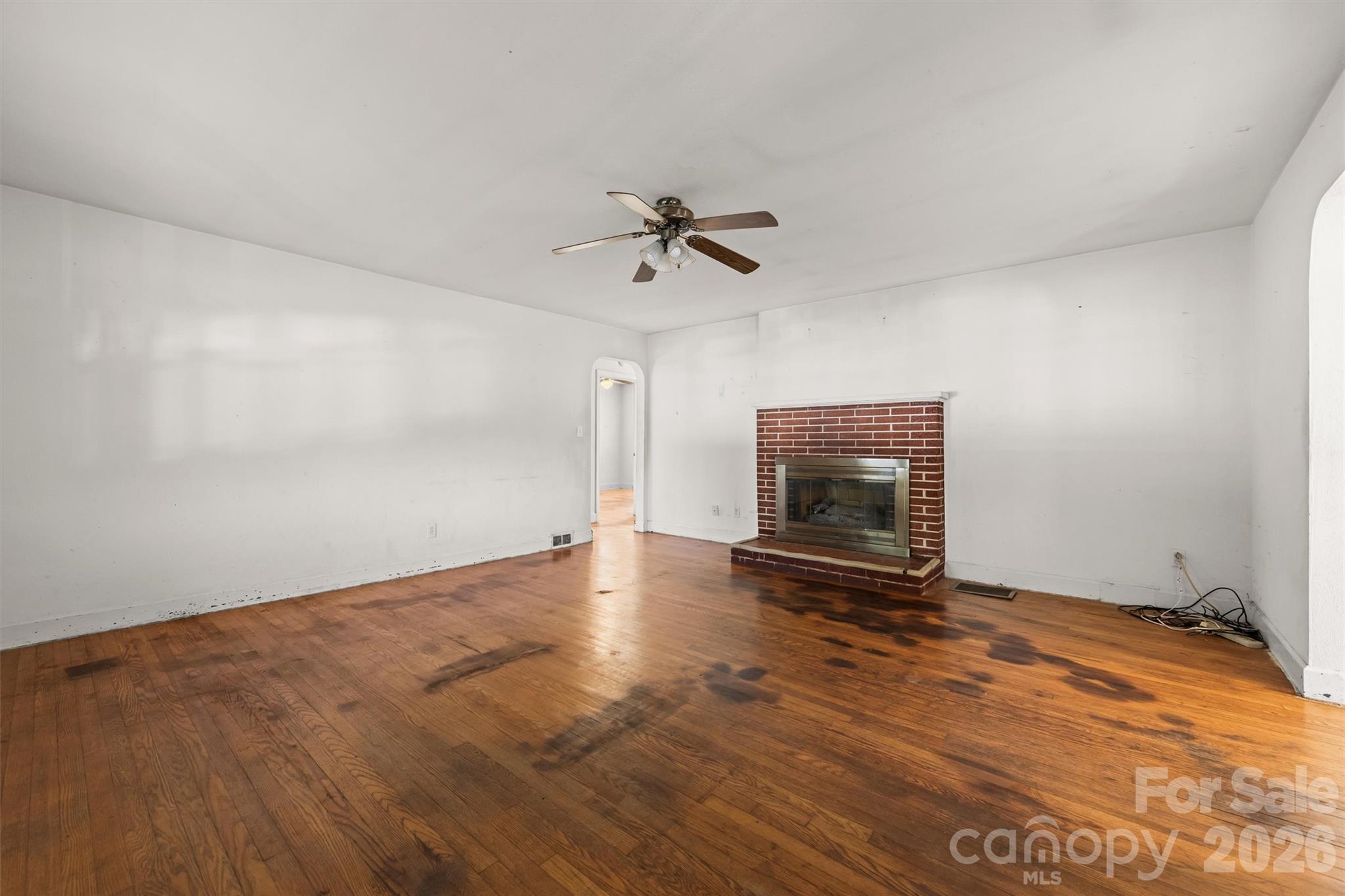 living room with original wood floors and brick fireplace - 108 Morgan Street, Canton