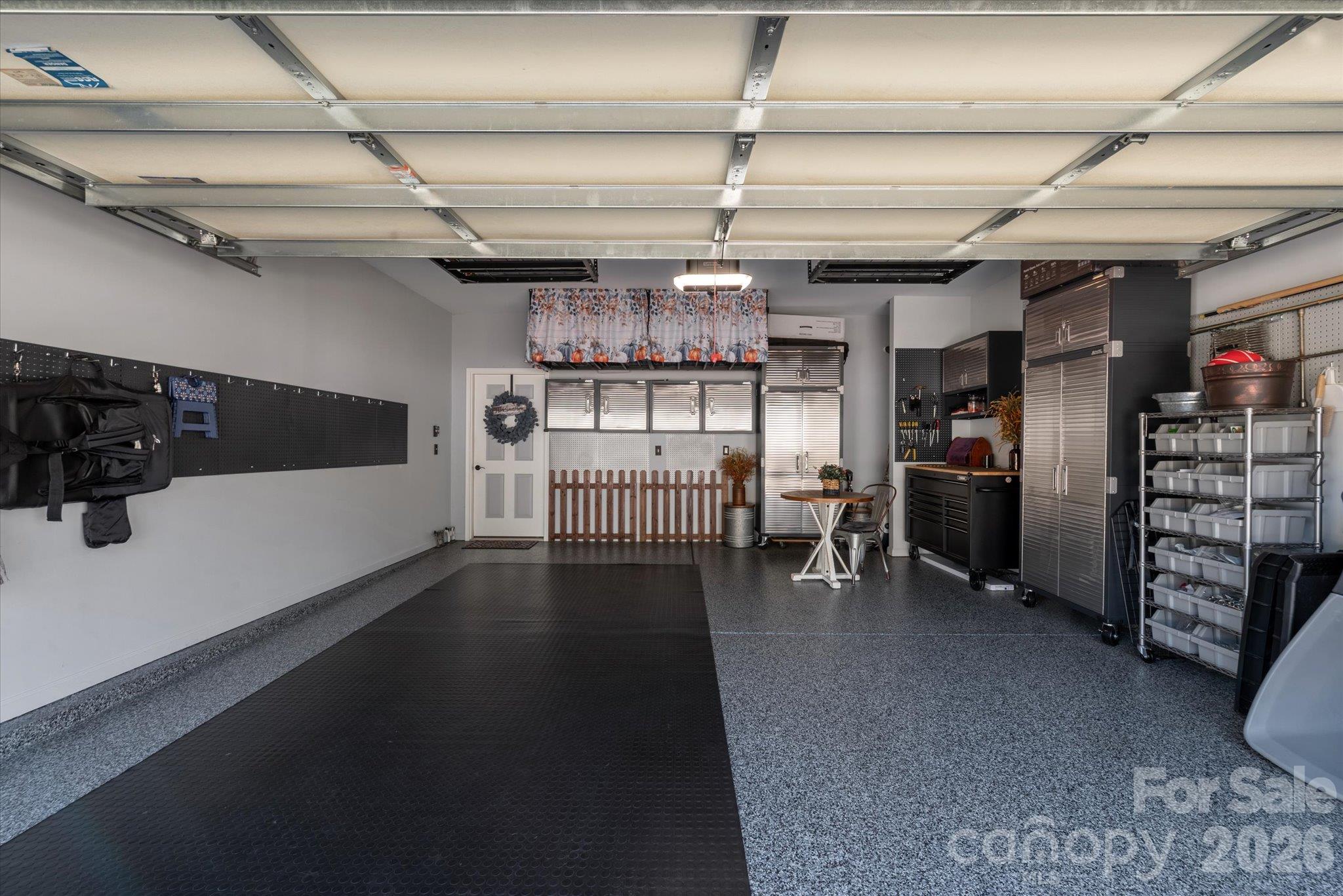 DREAM garage with epoxy floor, overhead storage, mounted stainless steel cabinets, pegboards for organizing, and new garage door system! - 23121 Whimbrel Circle, Indian Land