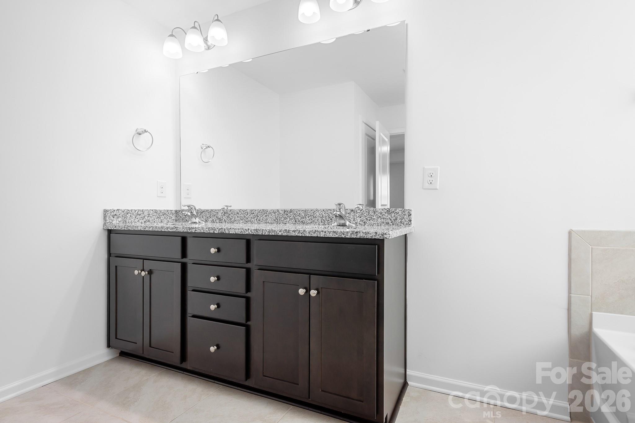 A generous vanity with ample counter space and storage adds everyday convenience to this beautifully appointed ensuite. - 3967 Lake Breeze Drive, Sherrills Ford