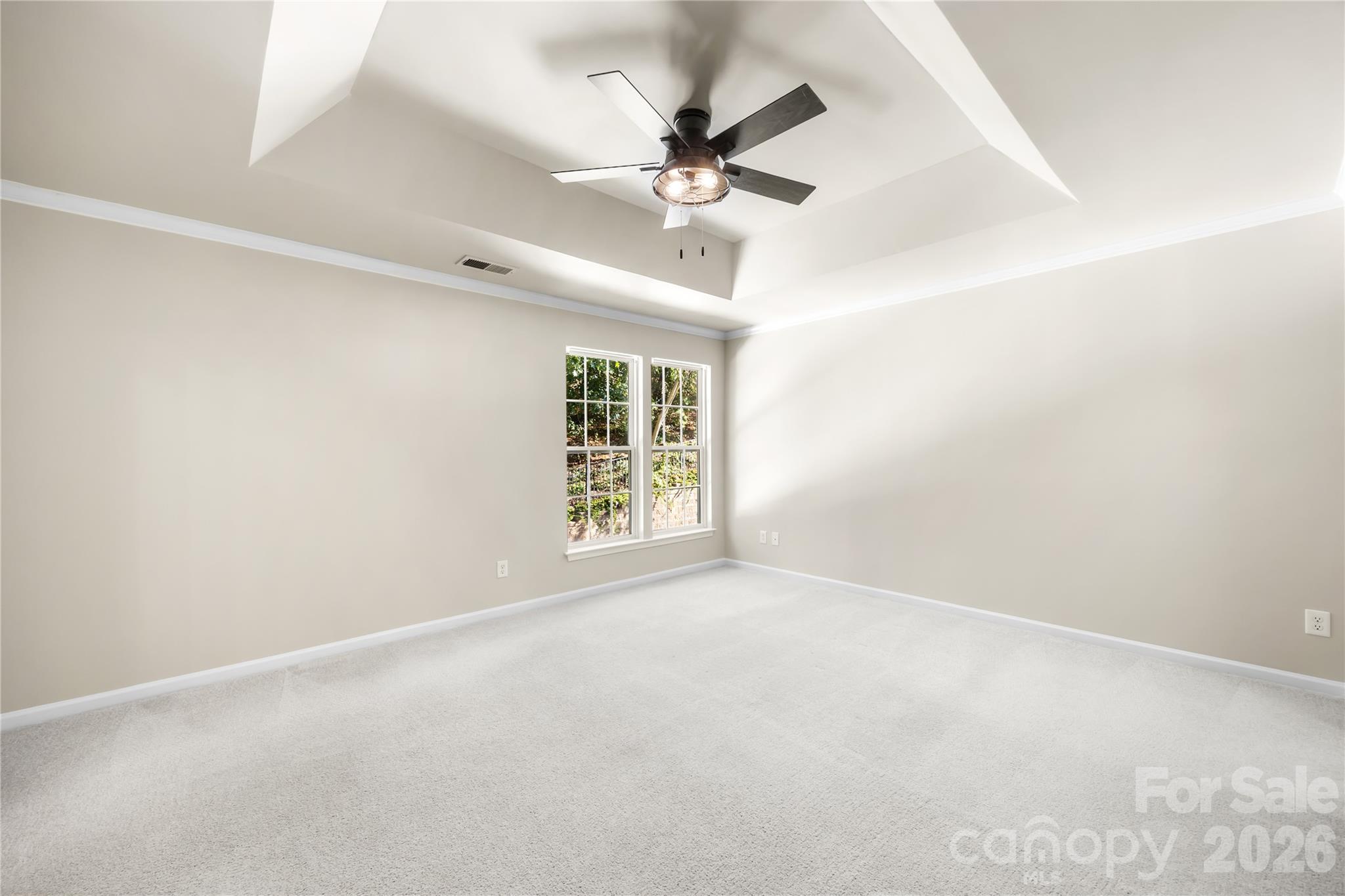 The primary bedroom features a tray ceiling and an updated ceiling fan - 156 N Arcadian Way, Mooresville