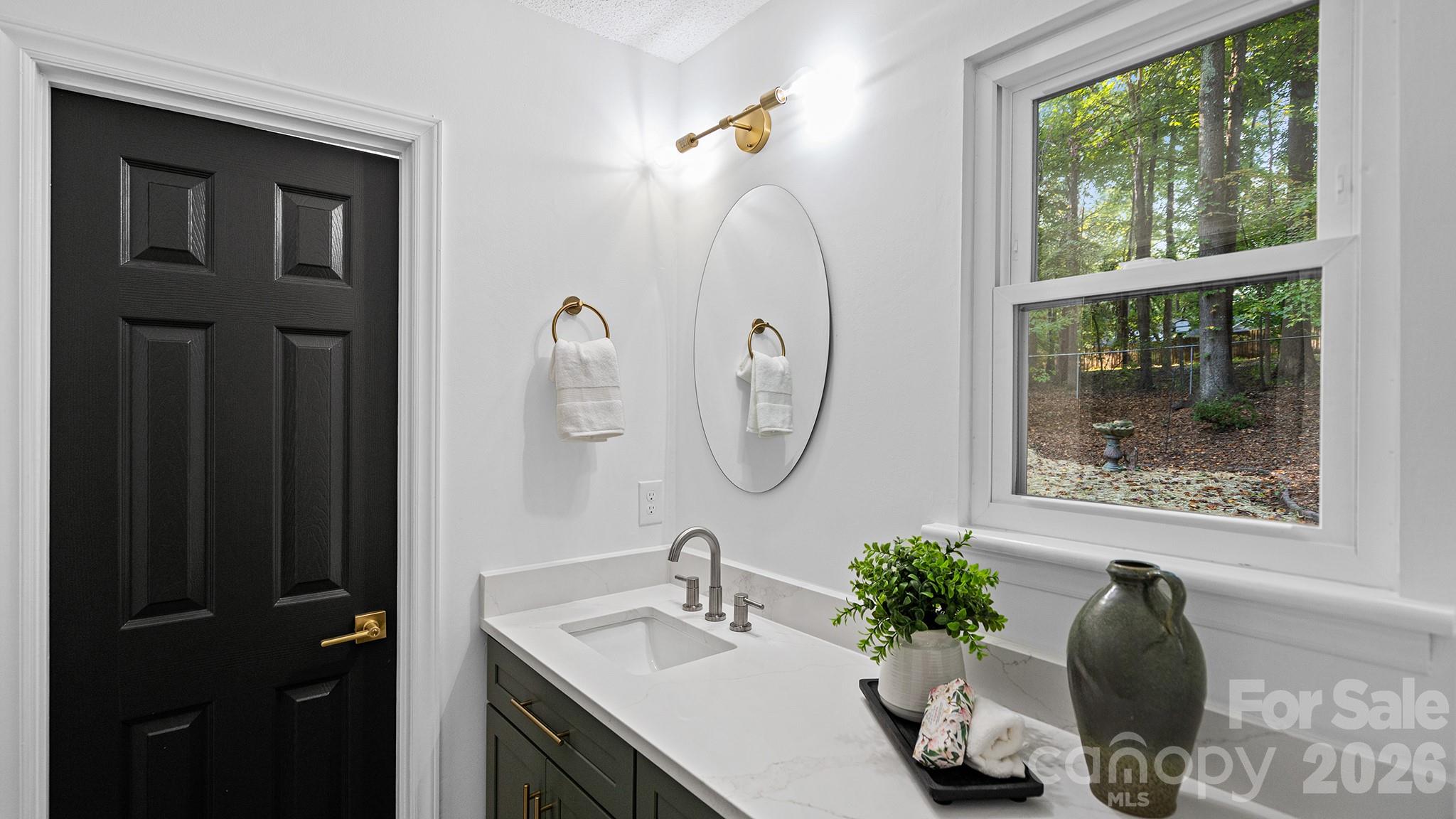 Primary Bathroom Separate Dressing Area with Sink, Mixed Metal Accents, and Access to Walk in Closet - 8001 Saddlehorse Lane, Charlotte