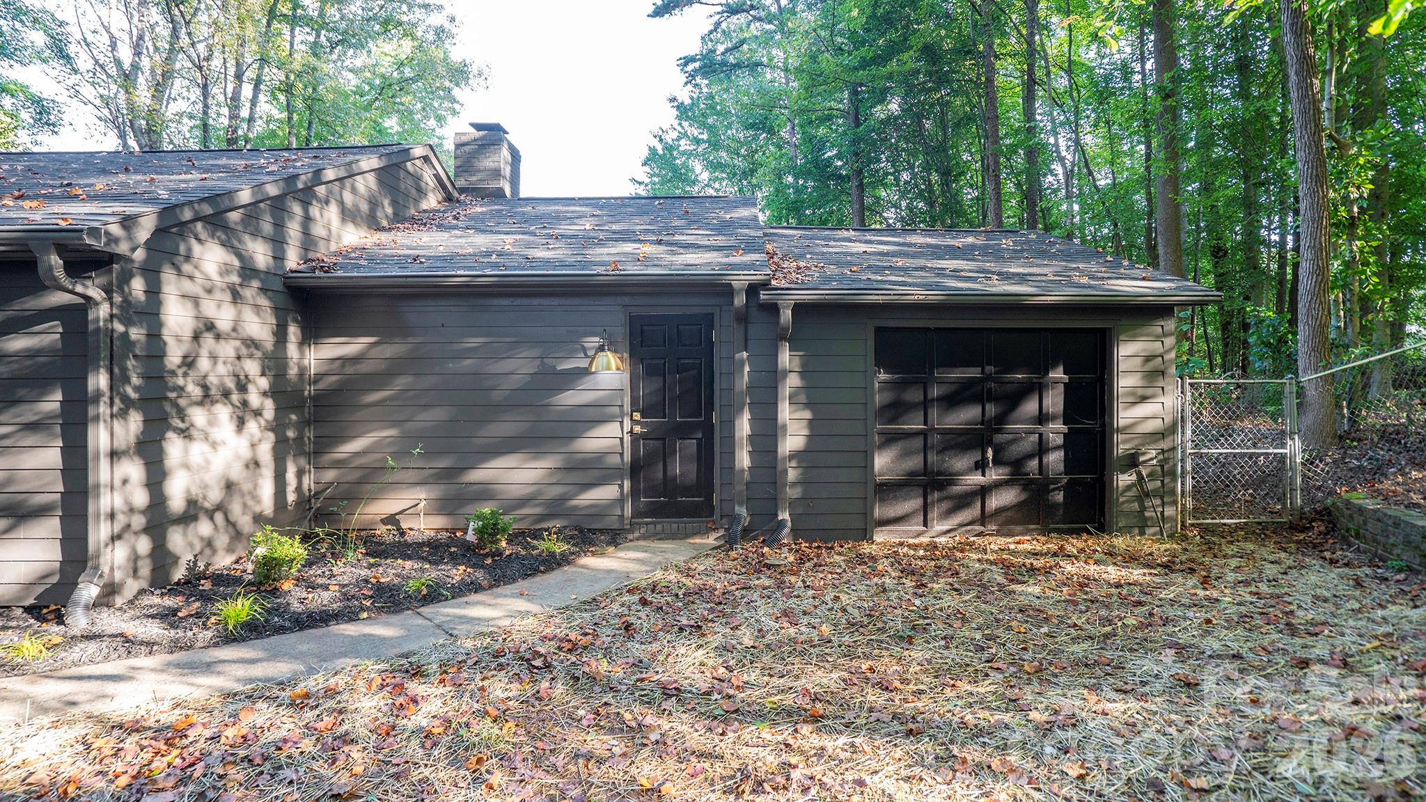 The Attached One Car Garage has Garage Doors on Front Side and Back Side - 8001 Saddlehorse Lane, Charlotte