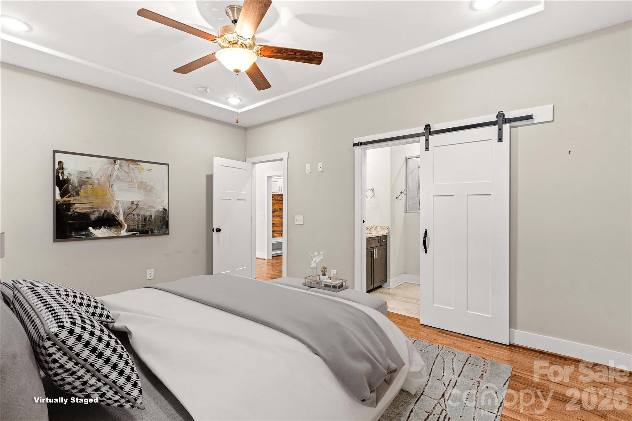Primary bedroom with tray ceiling and sliding door leading to en suite bathroom. - 178 Nellwood Court, Mocksville