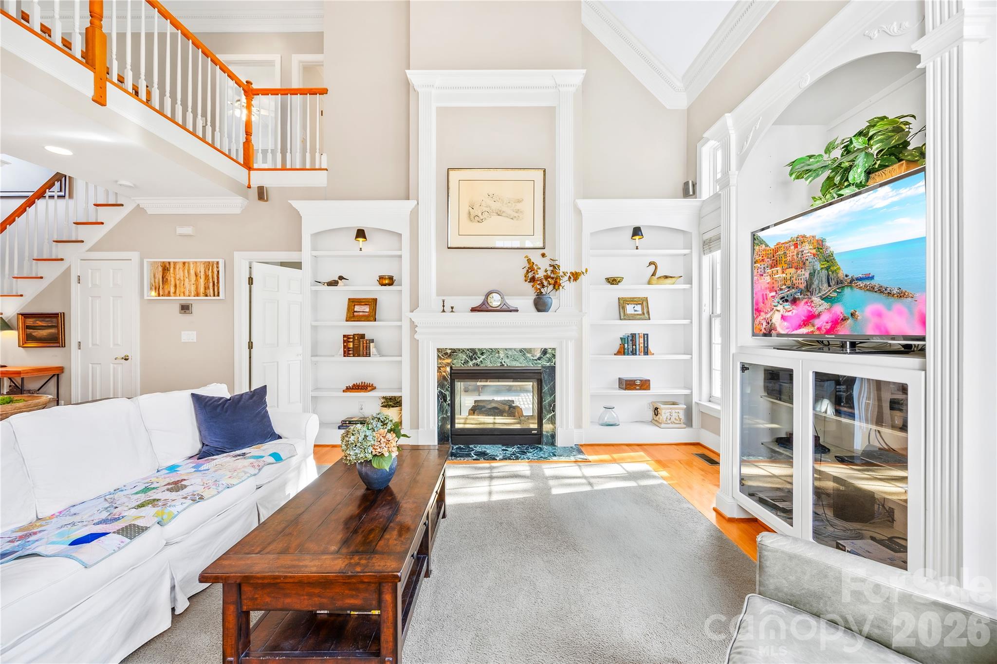 Living Room with built-in shelves & double-sided fireplace - 1410 Pine Needle Lane, Mooresville