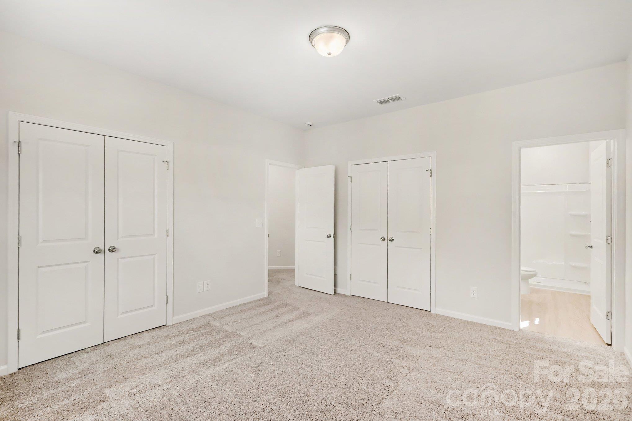 Photo of primary bedroom which has two closets and an ensuite bathroom. - 125 Buffalo Avenue NW, Concord