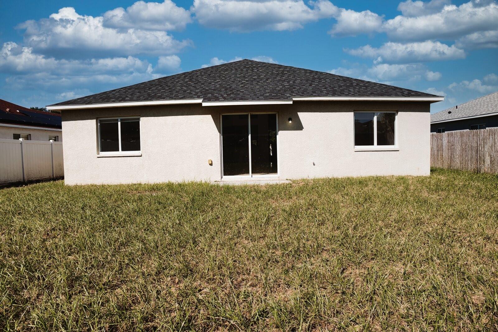 Rear exterior view of the home showing the backyard and patio. - 11007 WHITECAP DR, RIVERVIEW