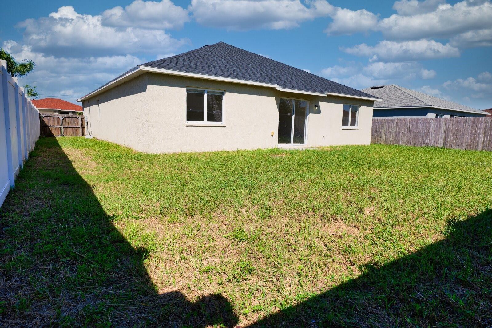 Rear exterior view of the home showing the backyard and patio. - 11007 WHITECAP DR, RIVERVIEW