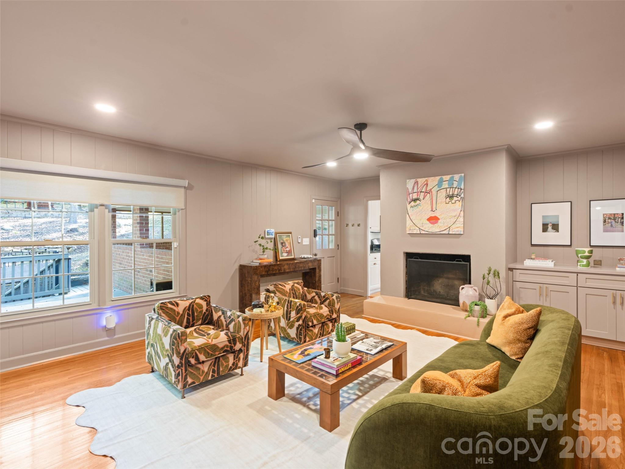 Living room just off the kitchen features a newly refurbished concrete masonry wood burning fireplace, built-in cabinetry, beautiful hardwood floors and Convenient access to the carport. - 6626 Rocky Falls Road, Charlotte