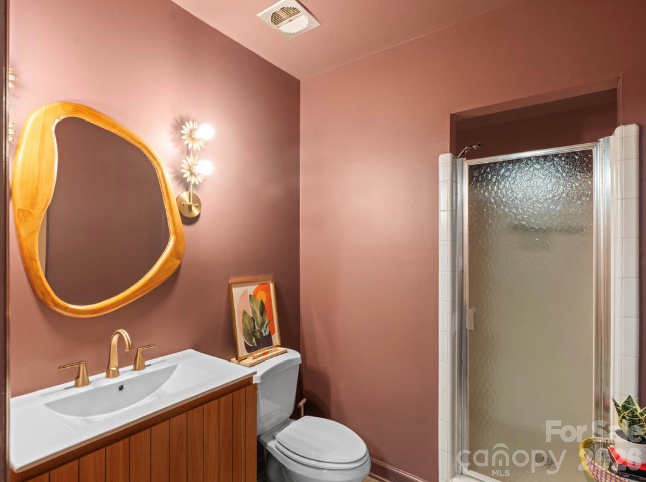 The full bathroom in the basement has been thoughtfully refreshed with fresh paint, a new vanity, an updated vanity mirror, and modern lighting. - 6626 Rocky Falls Road, Charlotte