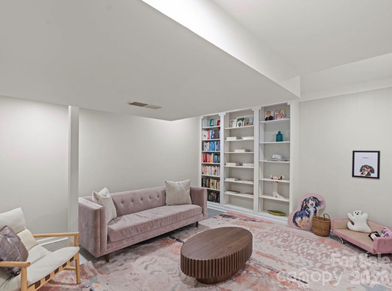 Discover yet another versatile flex space in the basement, currently enjoyed as a cozy hangout and reading room. This additional area offers the perfect spot to unwind with a good book, create a quiet retreat, or explore other possibilities to suit your needs. Please note that only a portion of this room is included in the home’s heated living area (HLA) due to ceiling-height limitations where the HVAC vent extends lower. - 6626 Rocky Falls Road, Charlotte