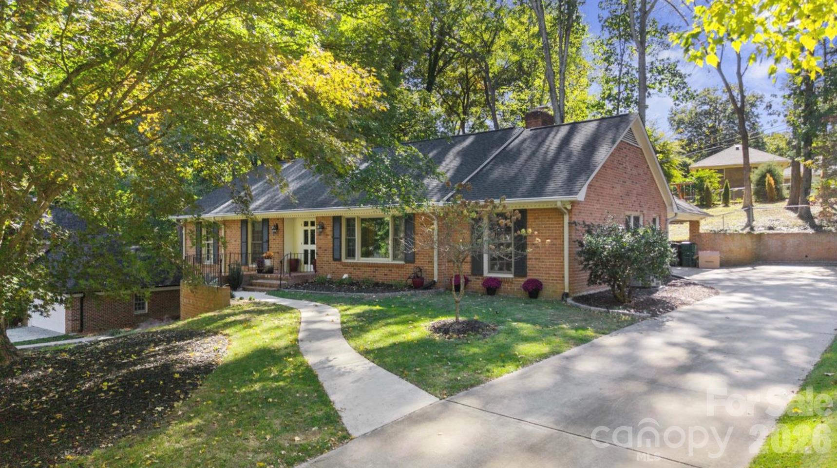 This showcases the extensive concrete driveway for tons of parking and sidewalk to the front porch - 6626 Rocky Falls Road, Charlotte