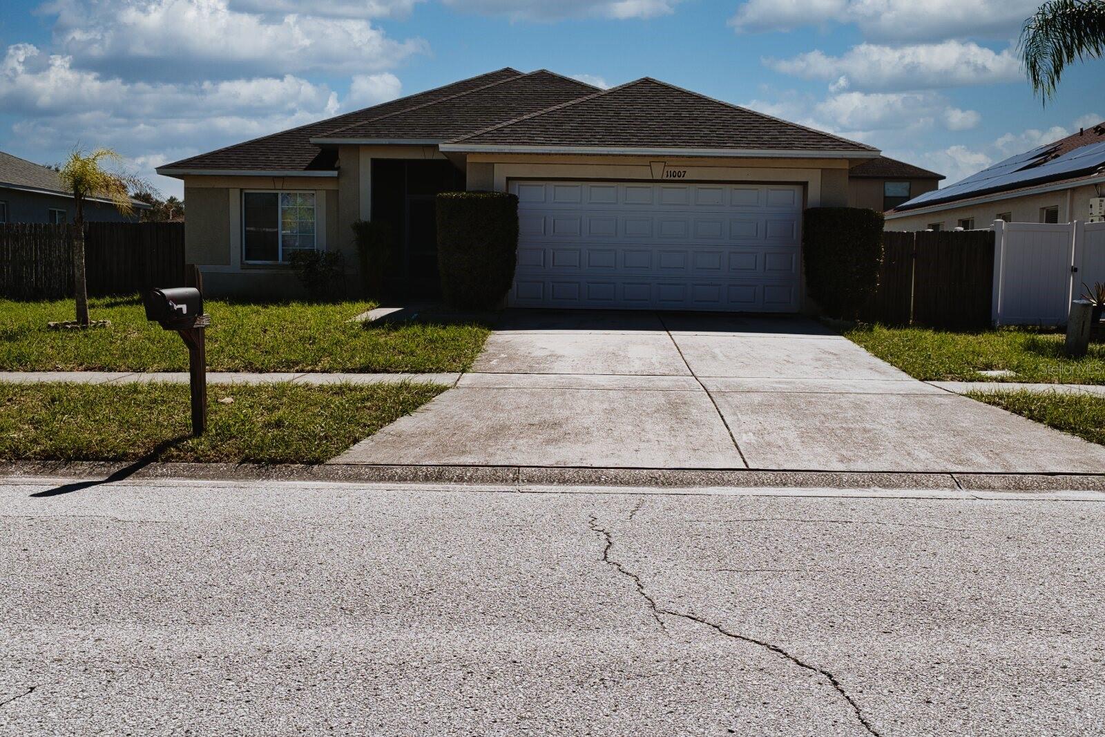 Front exterior view of the home showing the main entrance and front yard landscaping. - 11007 WHITECAP DR, RIVERVIEW