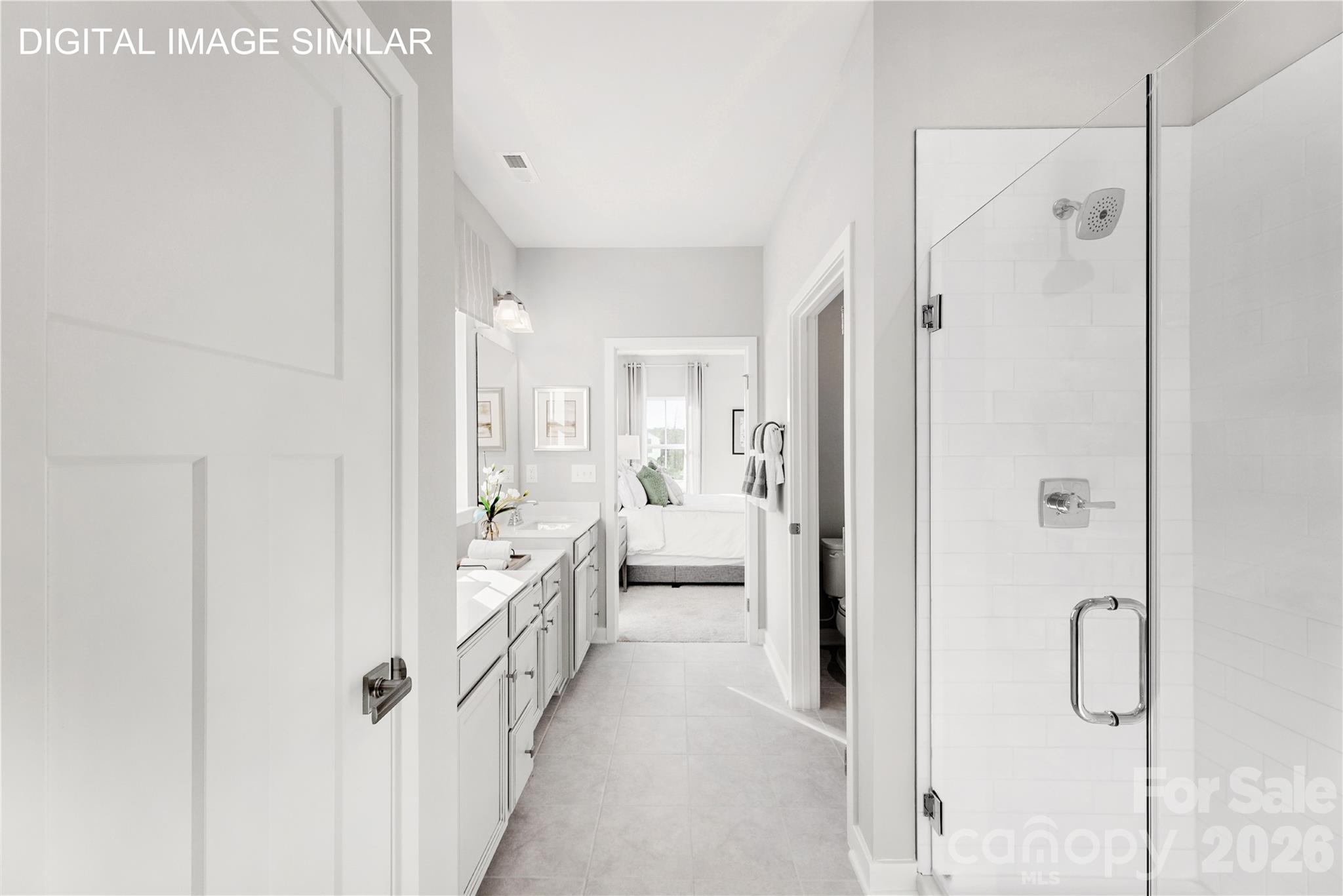 Spa-like primary bath with dual vanities, private water closet, linen storage, and walk-in shower featuring dual shower heads and built-in bench. - 11237 Emerson Landing Drive, Charlotte