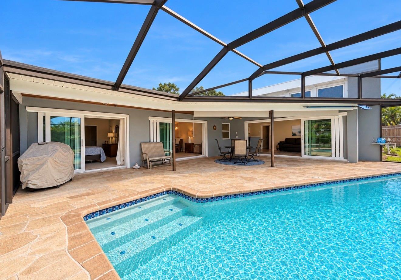Screened Enclosed pool looking at the back of home - 9690 LEEWARD AVE, LARGO