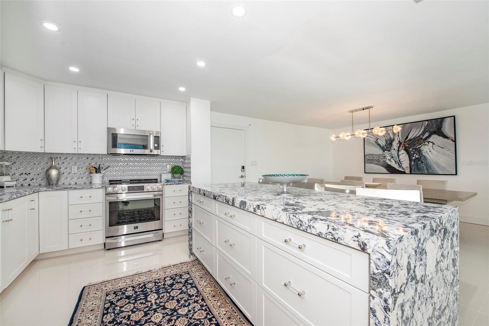 Kitchen has an open layout and center island with buffet seating for four... - 675 S GULFVIEW BLVD #704, CLEARWATER