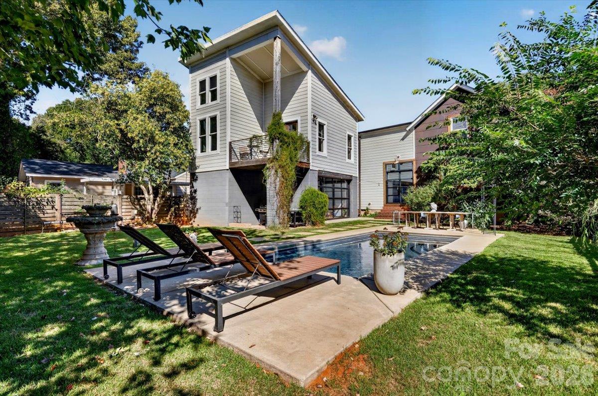 A true backyard oasis was thoughtfully designed for enjoyment. The fenced yard has an area for a fire pit, a covered area for your grill and outdoor pizza oven, and space for pets and people to enjoy. The outdoor pool is the star of the space. Sit on your primary suite balcony to enjoy a beverage while overlooking the space. - 521 Forest Lane, Rock Hill
