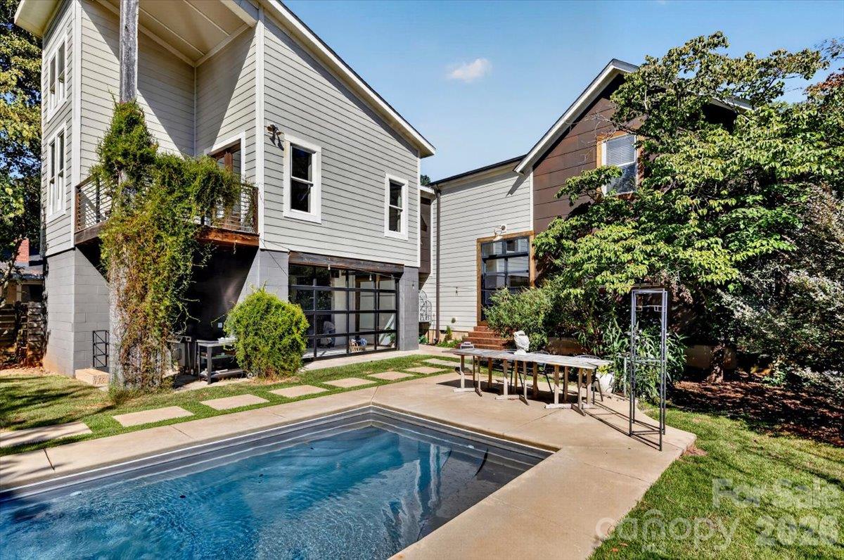 The pool is flanked by mature trees and an agacent living area - the pool house with its roll-up garage door. The space is temperature-controlled and has been used as a bedroom, studio, office, gym and rec room. - 521 Forest Lane, Rock Hill