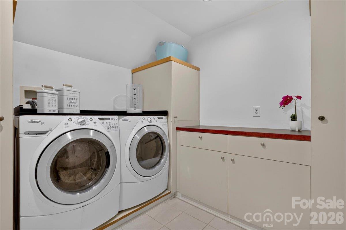 This perfect laundry room has space for clothes receptacles, an ironing board, cabinets for storing products, and counters for folding. - 521 Forest Lane, Rock Hill