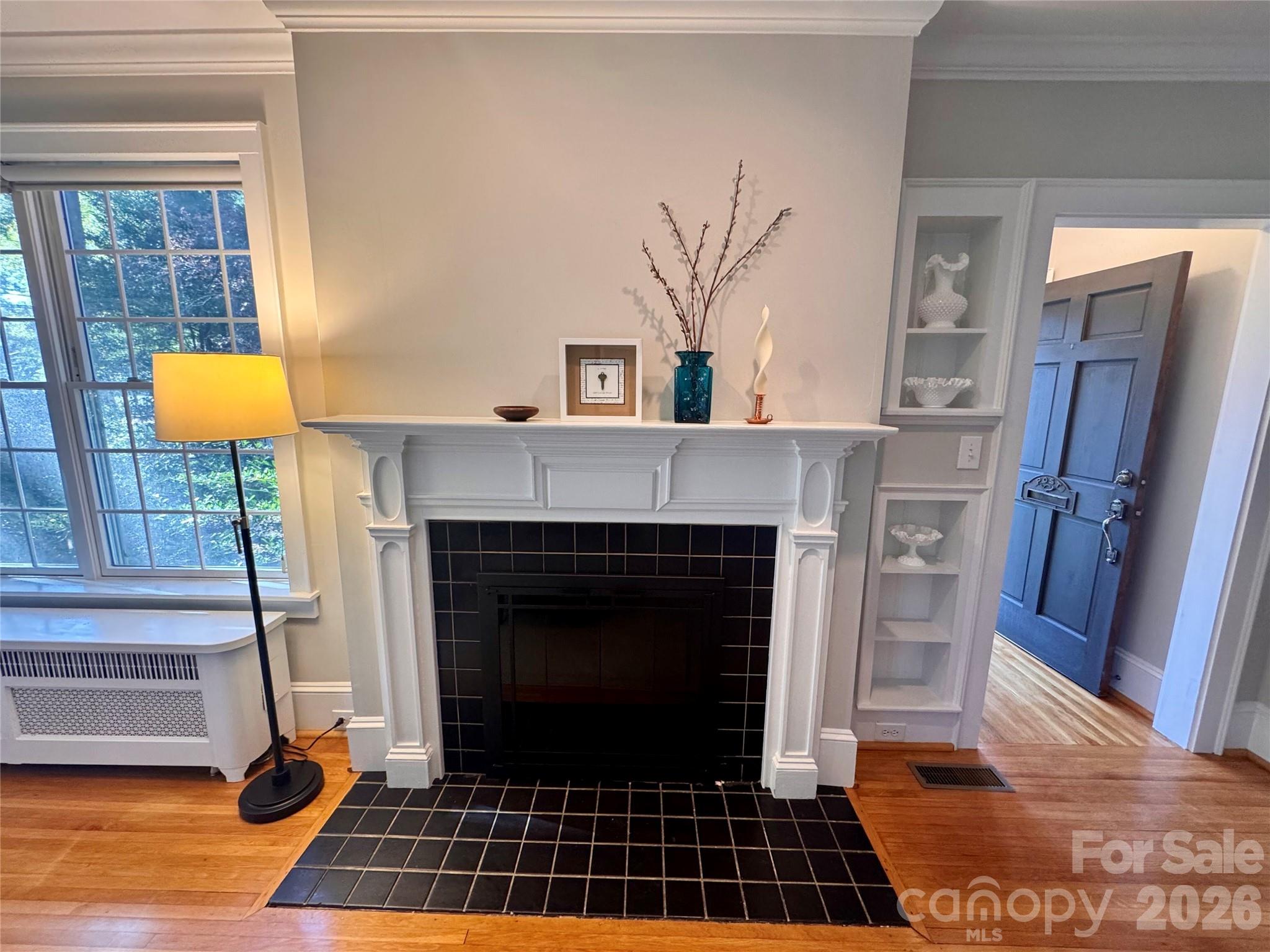 Fireplace with gas logs flanked by a built-in and picture window - 139 Louise Drive SE, Concord