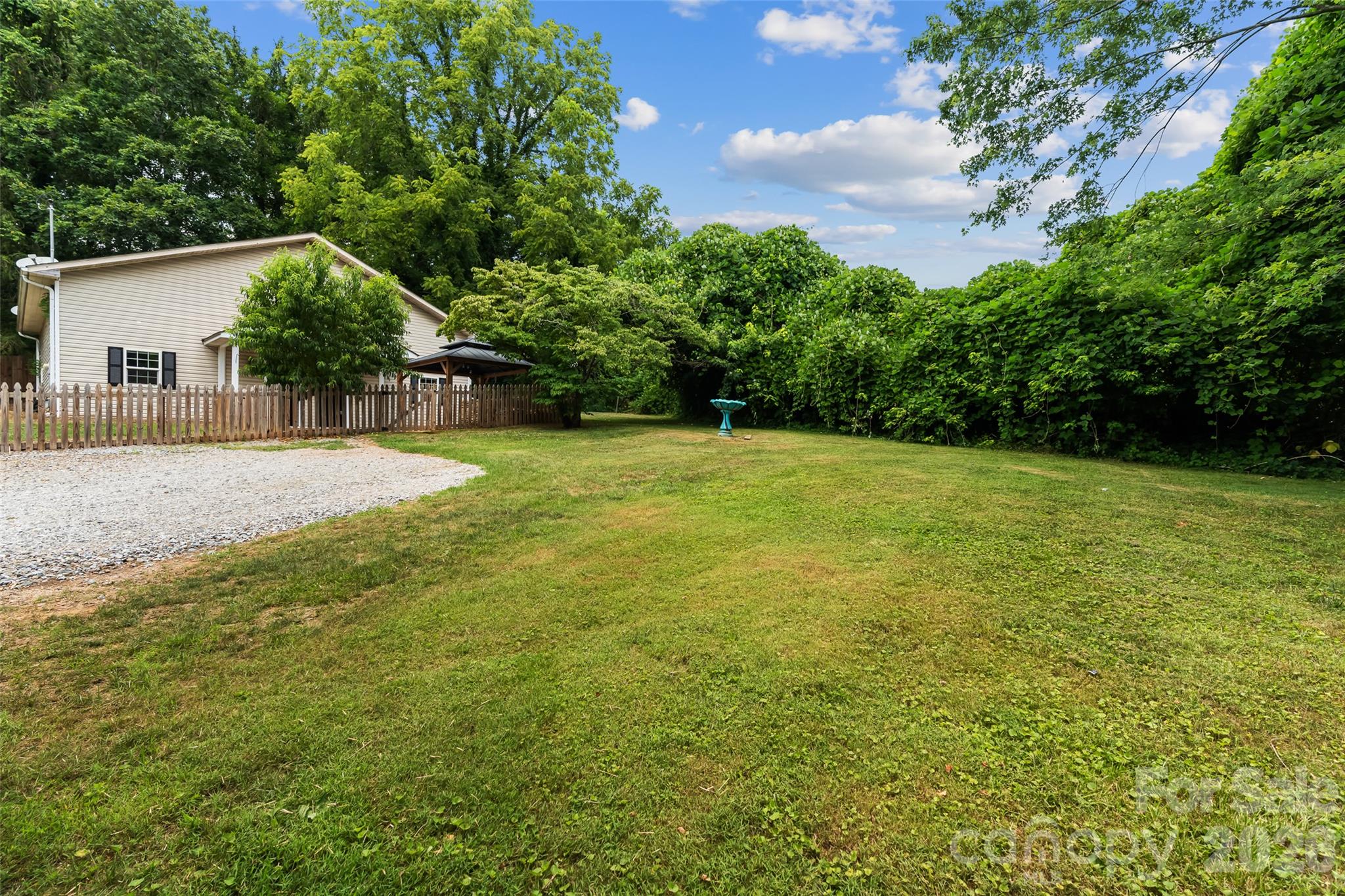 Front yard area with ample gravel parking area and mature landscaping. - 160 State Street, Asheville
