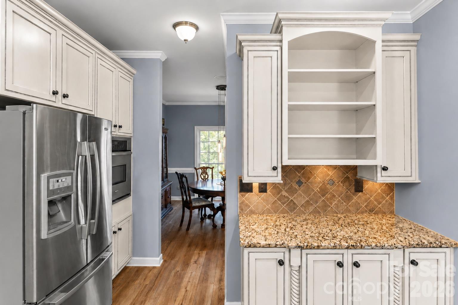 Including a natural gas cooktop, electric oven, breakfast bar, microwave, refrigerator and pantry. - 635 Highland Ridge Road, Mooresville