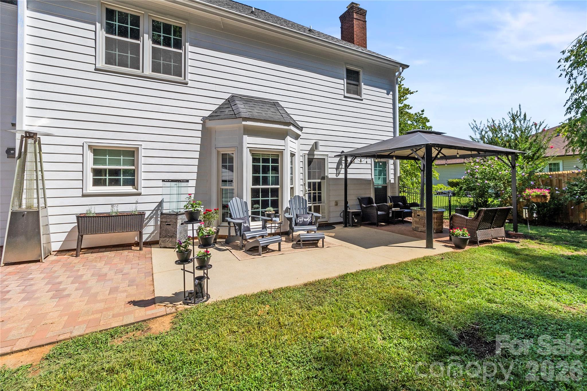 Beautiful backyard patio area featuring canopy and fire pit. - 635 Highland Ridge Road, Mooresville