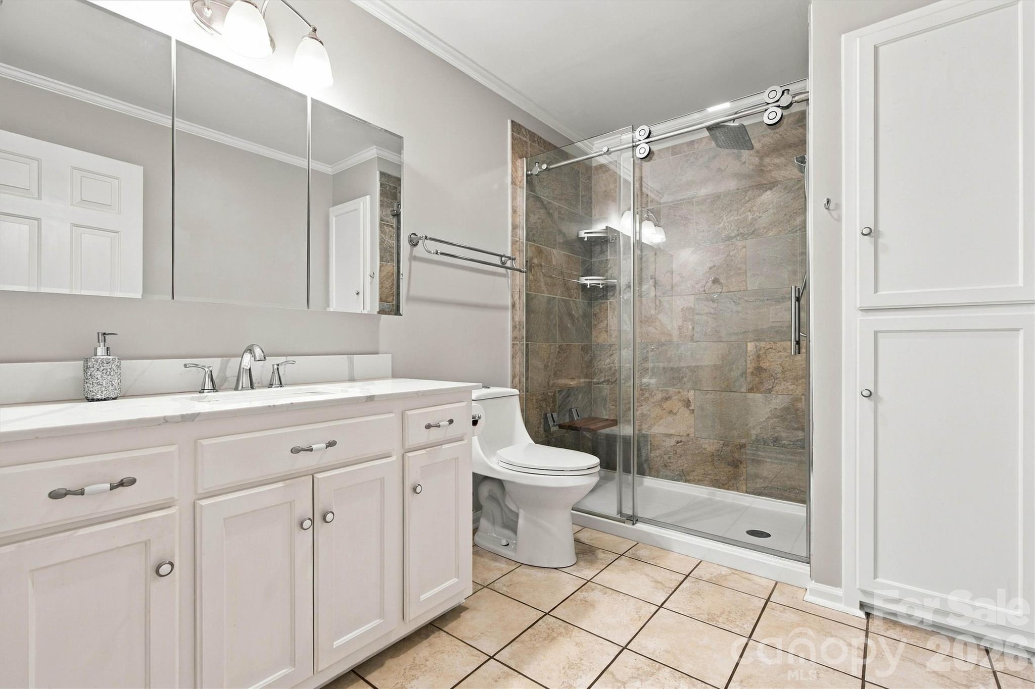 Beautifully updated Primary Bath with a new tile shower, commode, lighting, and lots of storage - 643 Shoal Road, Lincolnton