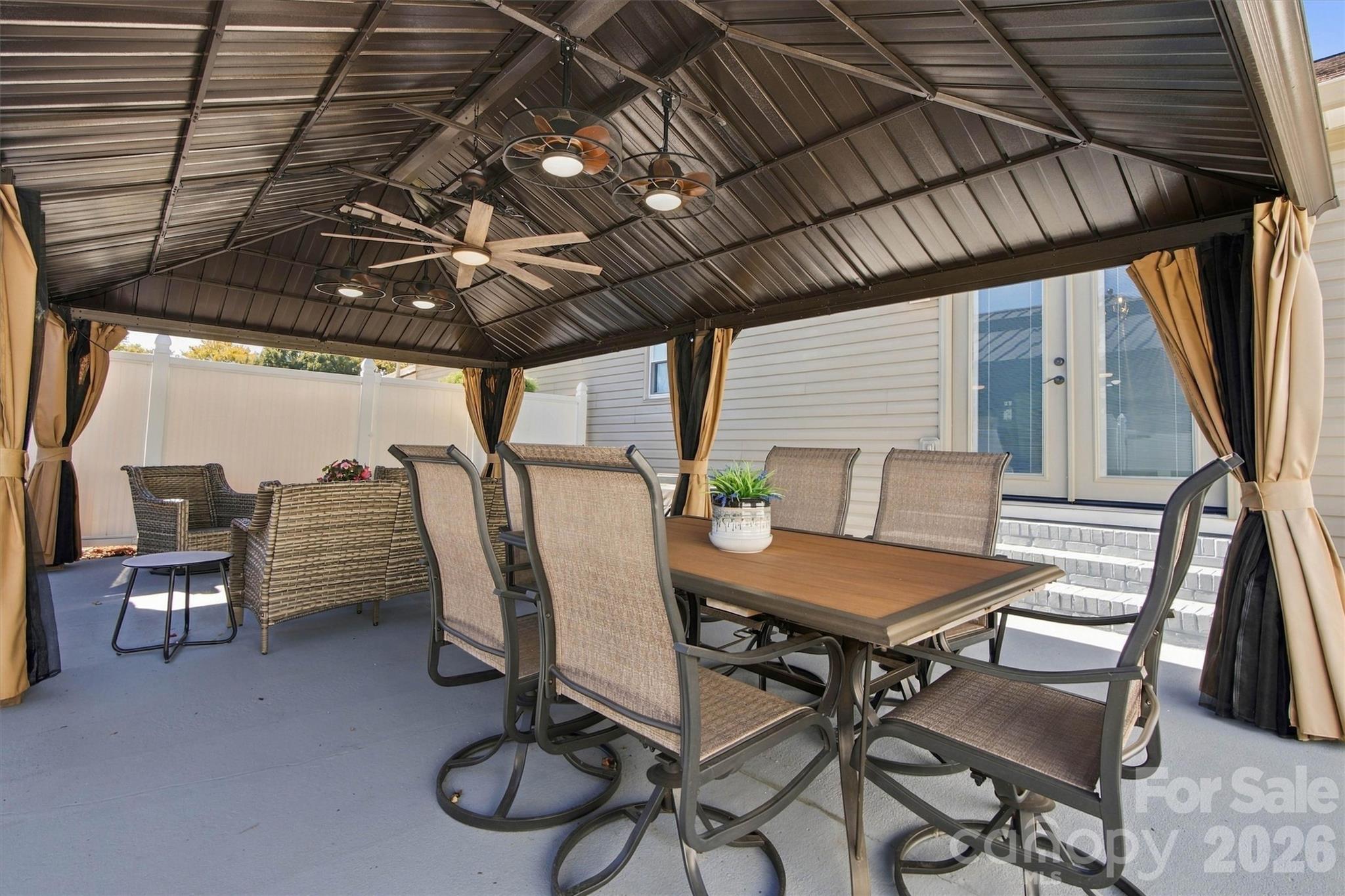 A beautiful outdoor living space, created by the 14'x24' Gazebo with ceiling fans, surrounded by a privacy fence with two gates. - 643 Shoal Road, Lincolnton