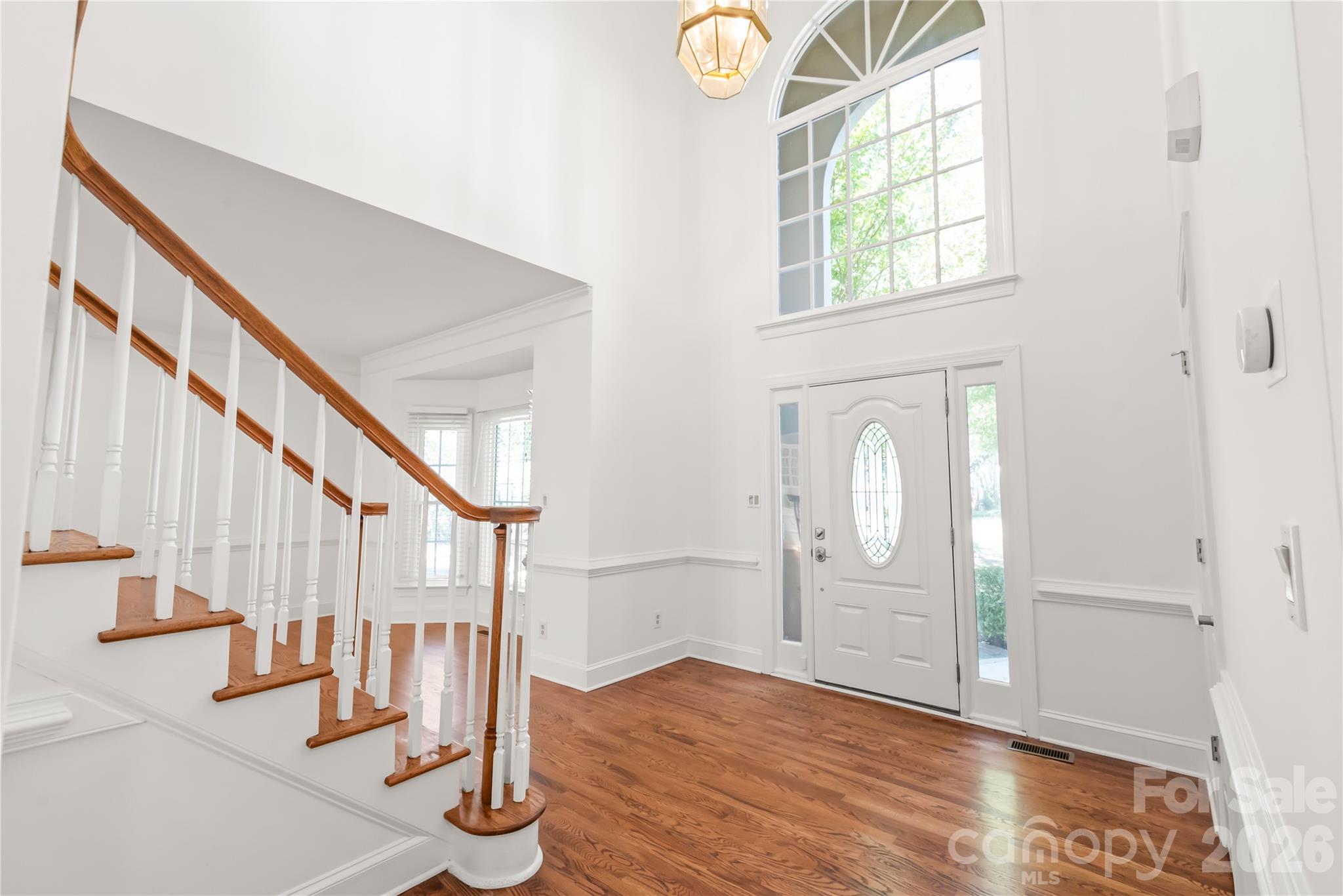 A grand first impression - soaring ceilings and cascading natural light greet you the moment you step inside this sun-drenched two-story foyer. - 11024 Stonepath Lane, Charlotte