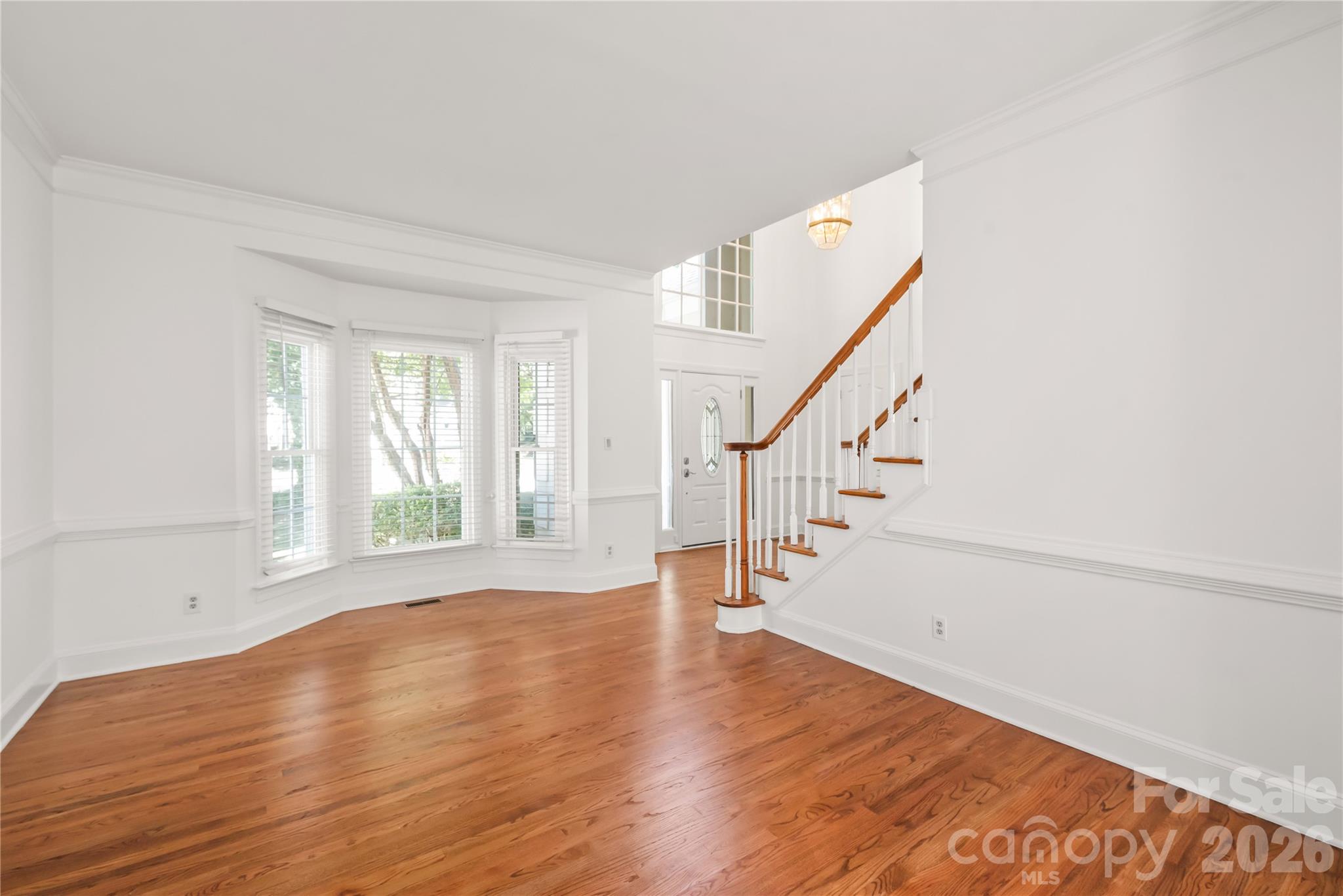 Sunlit, versatile, and finished to perfection - this main-level flex space features a charming bay window, crisp fresh paint, and brand new site-finished hardwoods. - 11024 Stonepath Lane, Charlotte