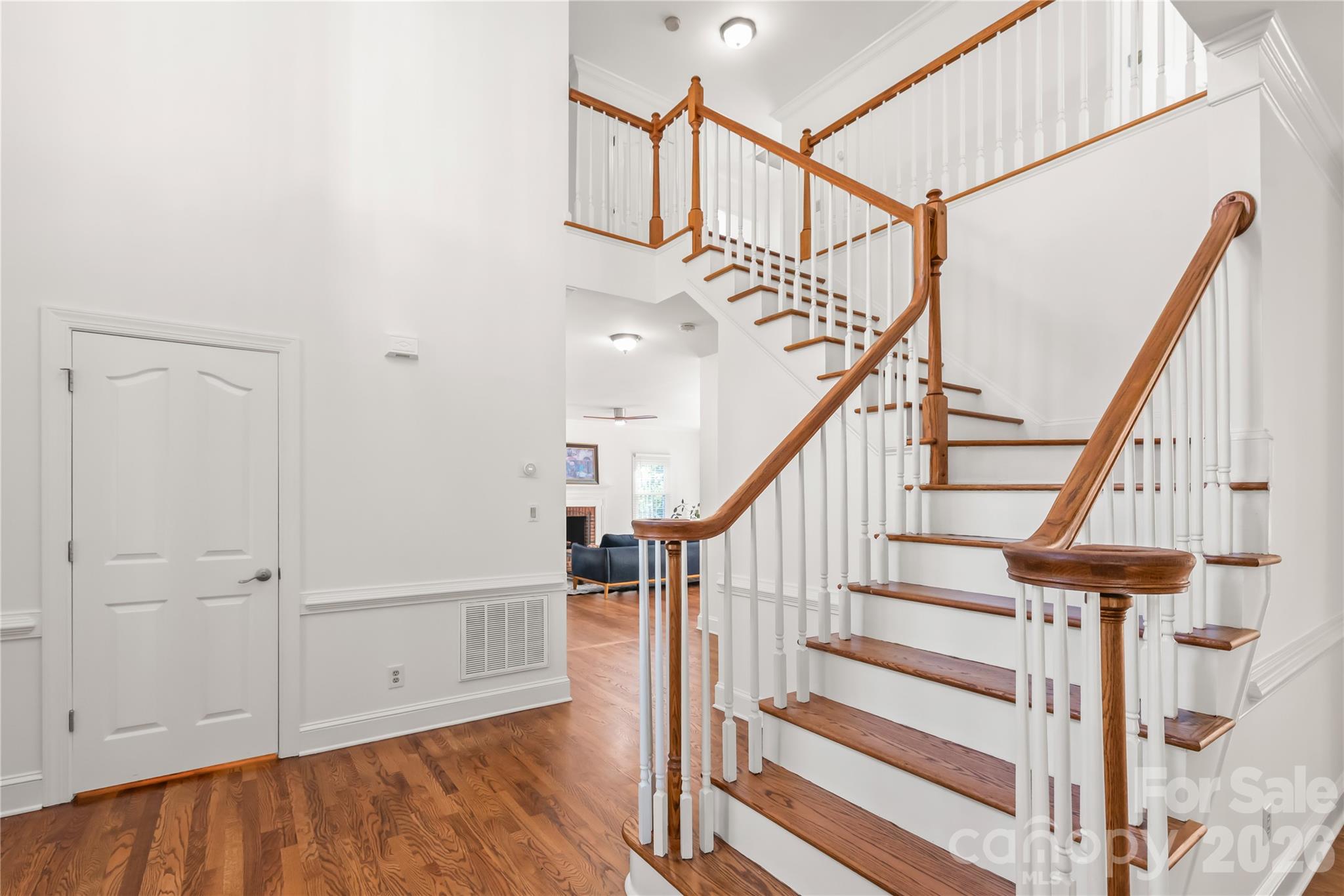 Elegance in every step...beautifully refinished hardwood stairs and railings seamlessly connect the levels with a sleek, polished, and modern look. - 11024 Stonepath Lane, Charlotte