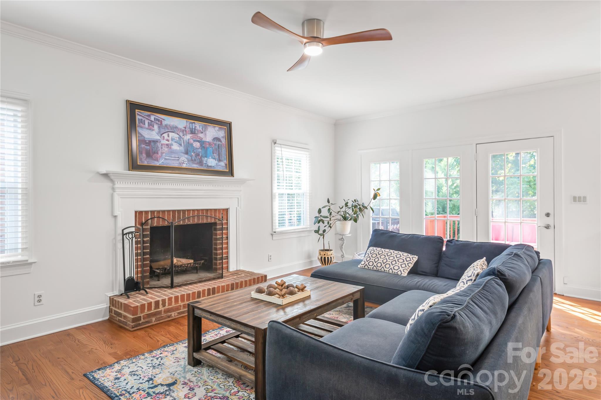 The heart of everyday comfort - unwind by the cozy fireplace in this bright, inviting living room, beautifully elevated with crisp fresh paint and rich hardwood floors. - 11024 Stonepath Lane, Charlotte