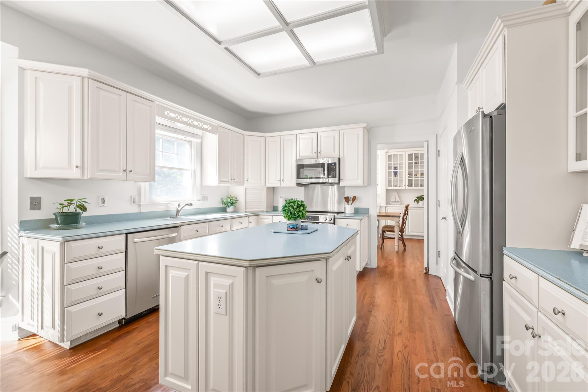 Chef's kitchen featuring an expansive center island, abundant cabinet storage, and rich hardwood floors that combine style with everyday functionality. - 11024 Stonepath Lane, Charlotte