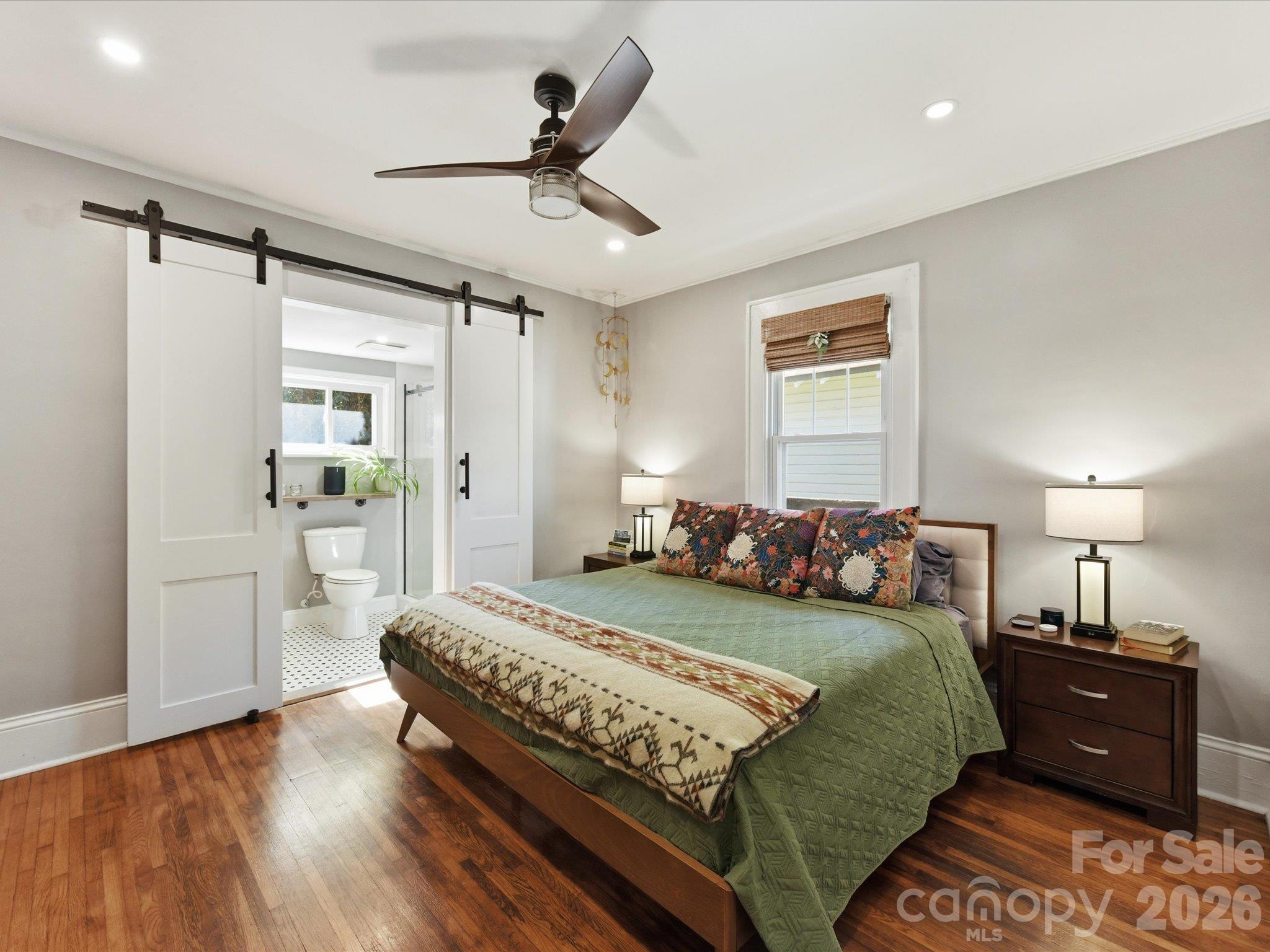Custom barn doors leading to updated primary bathroom - 415 West Boulevard, Charlotte
