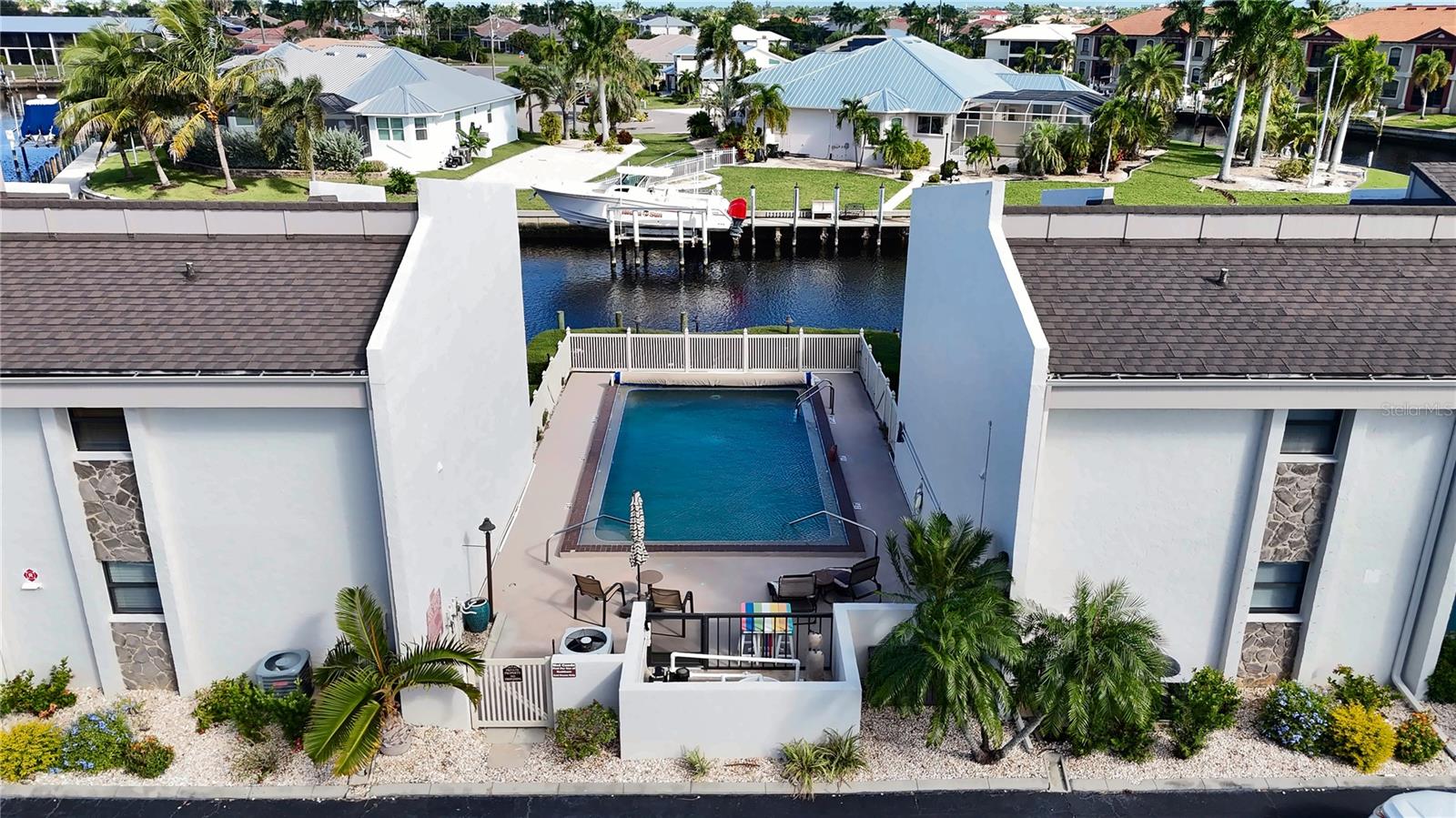 Aerial view of the community pool between the condo buildings, just steps from the first-floor unit and the canal docks. - 1423 MEDITERRANEAN DR #B, PUNTA GORDA
