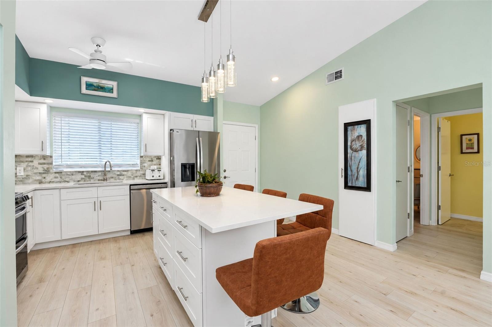 The kitchen features white cottage-style cabinetry, a decorative backslash and QUARTZ countertops. - 6468 HAMLET DR #B, ENGLEWOOD