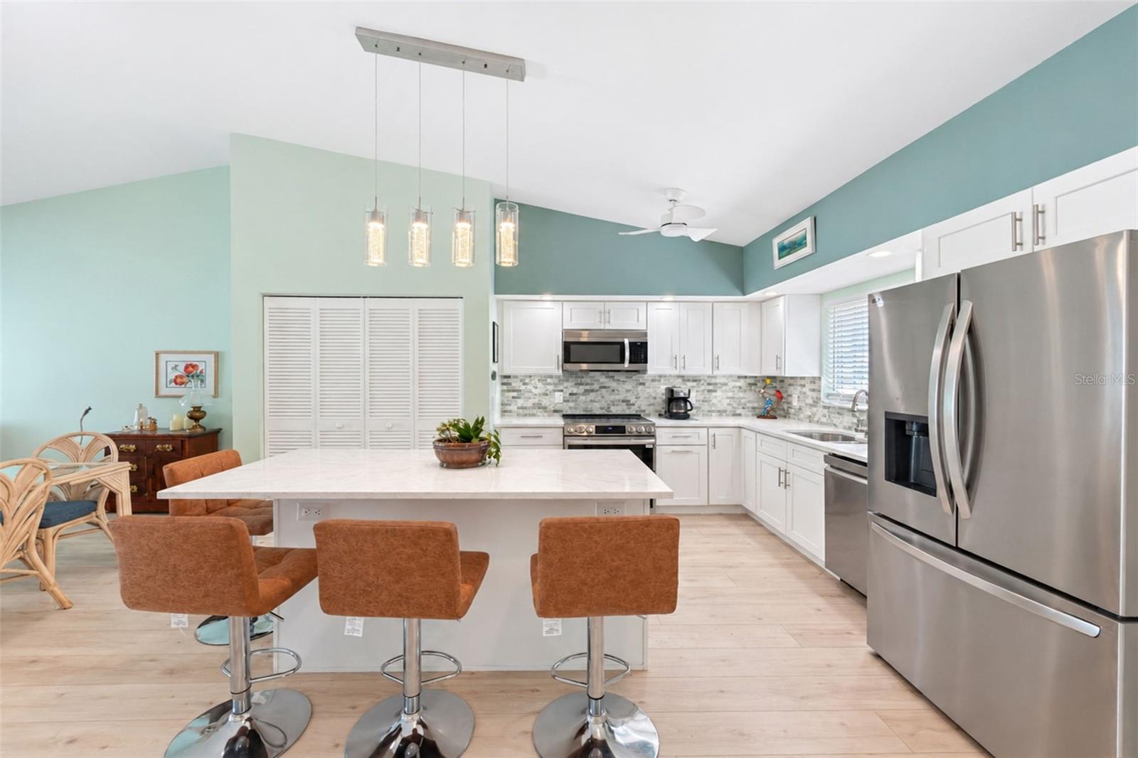 The kitchen island provides extra seating, beautiful pendant lighting and extra cabinetry. - 6468 HAMLET DR #B, ENGLEWOOD