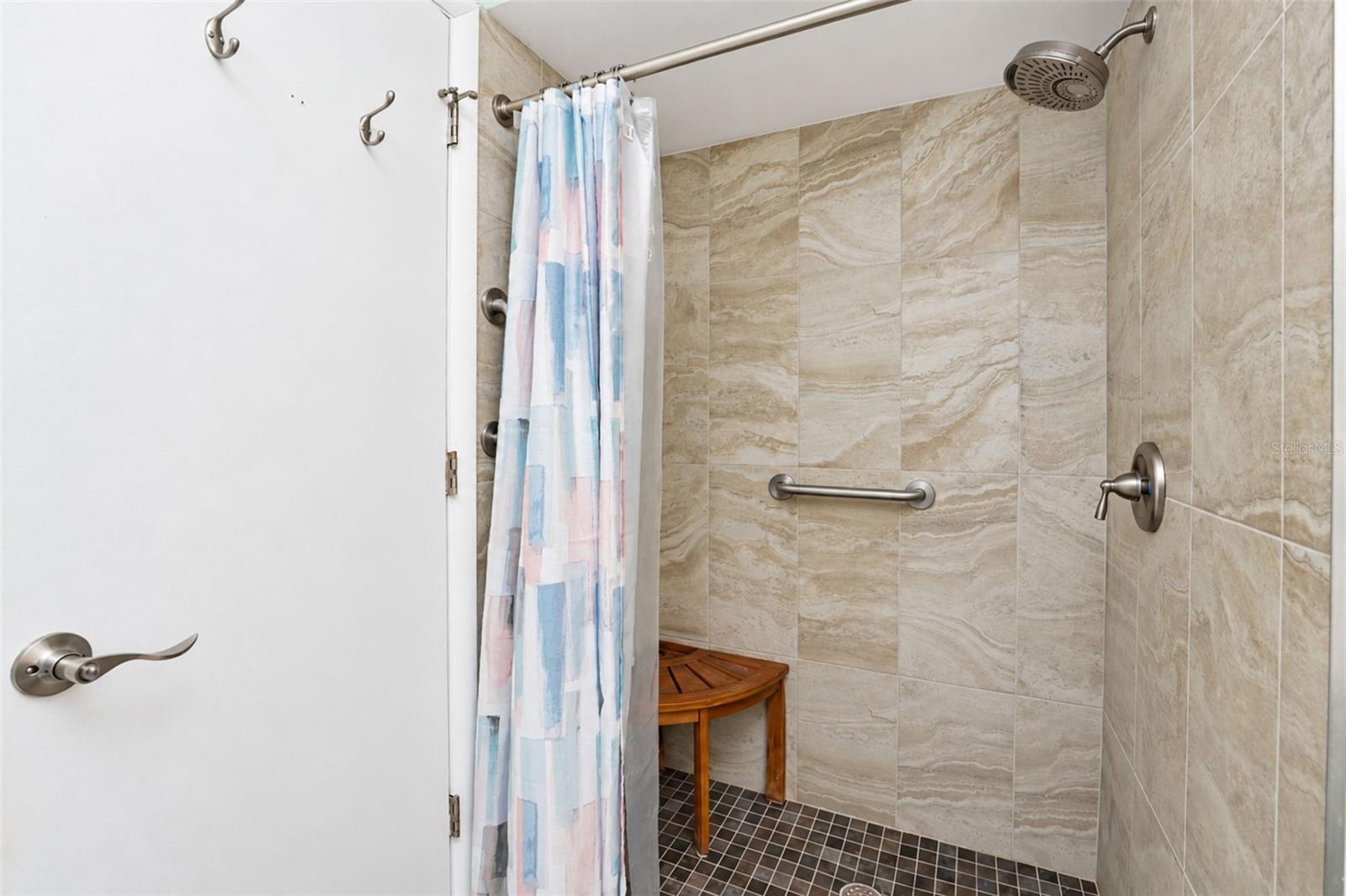 The ensuite bathroom has a step-in shower with new tile. - 6468 HAMLET DR #B, ENGLEWOOD