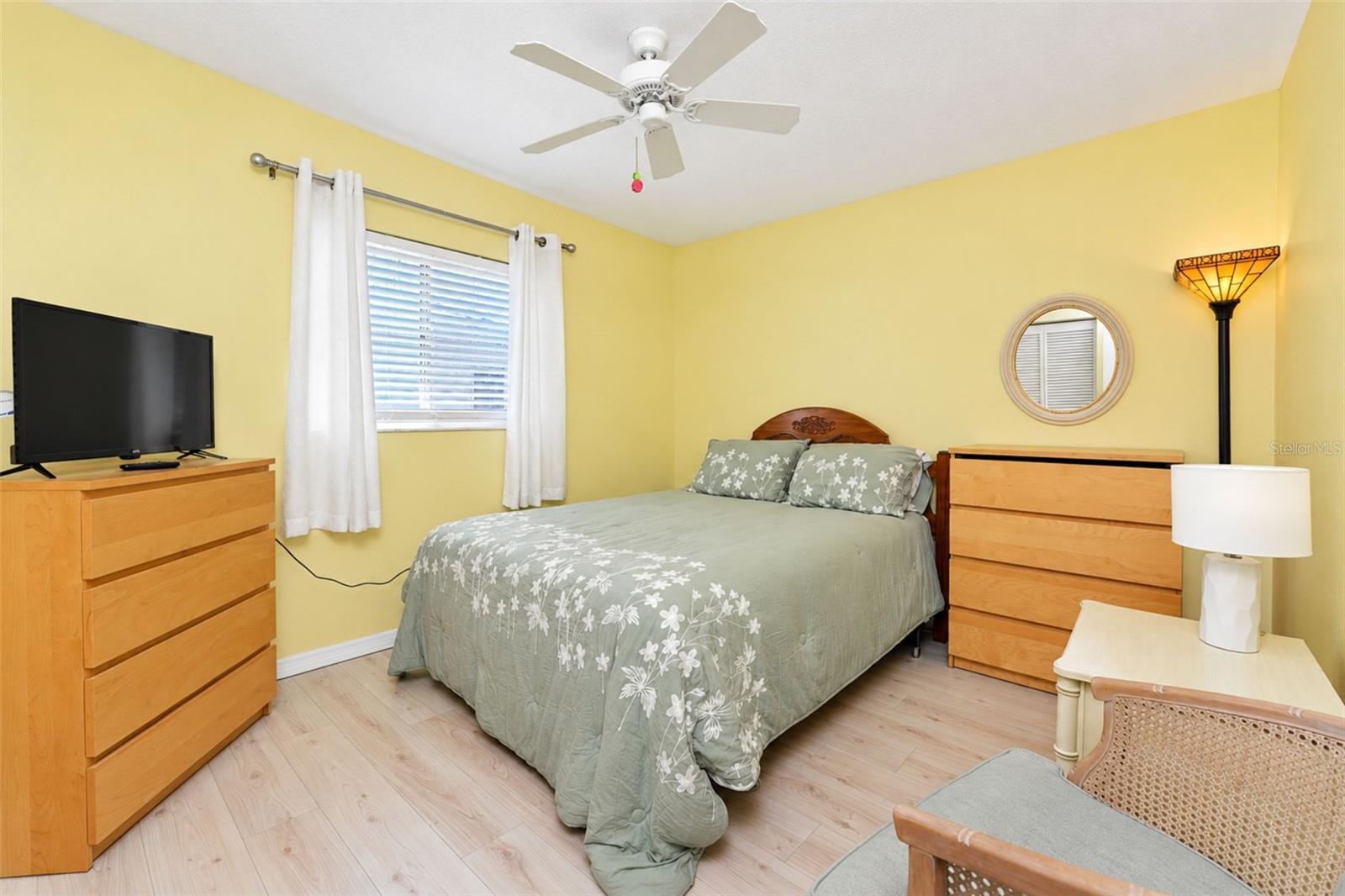 The guest bedroom features wood laminate flooring and a ceiling fan. - 6468 HAMLET DR #B, ENGLEWOOD