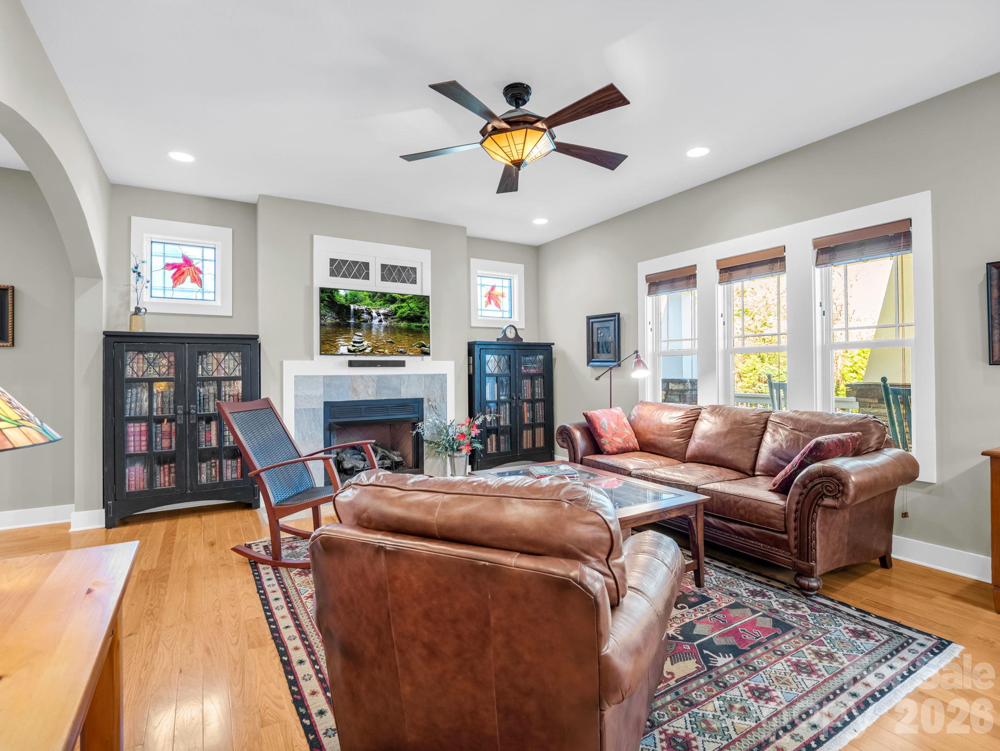 Natural gas fireplace in living room, abundant natural light, bookshelves/soundbar/tv's and mounts convey - 376 Scarlet Tanager Court, Arden